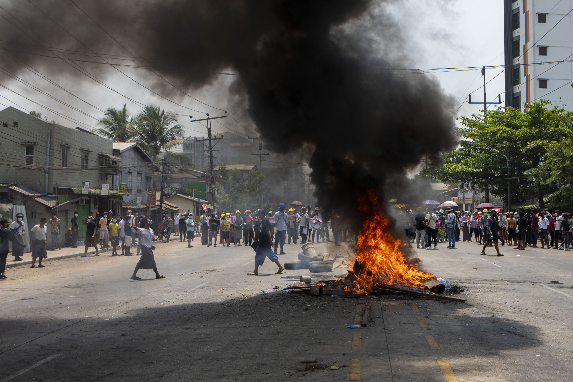 Anti-coup protesters stand behind burning tyres during a demonstration on March 31, 2021. Photo: ZUMA Wire/dpa
