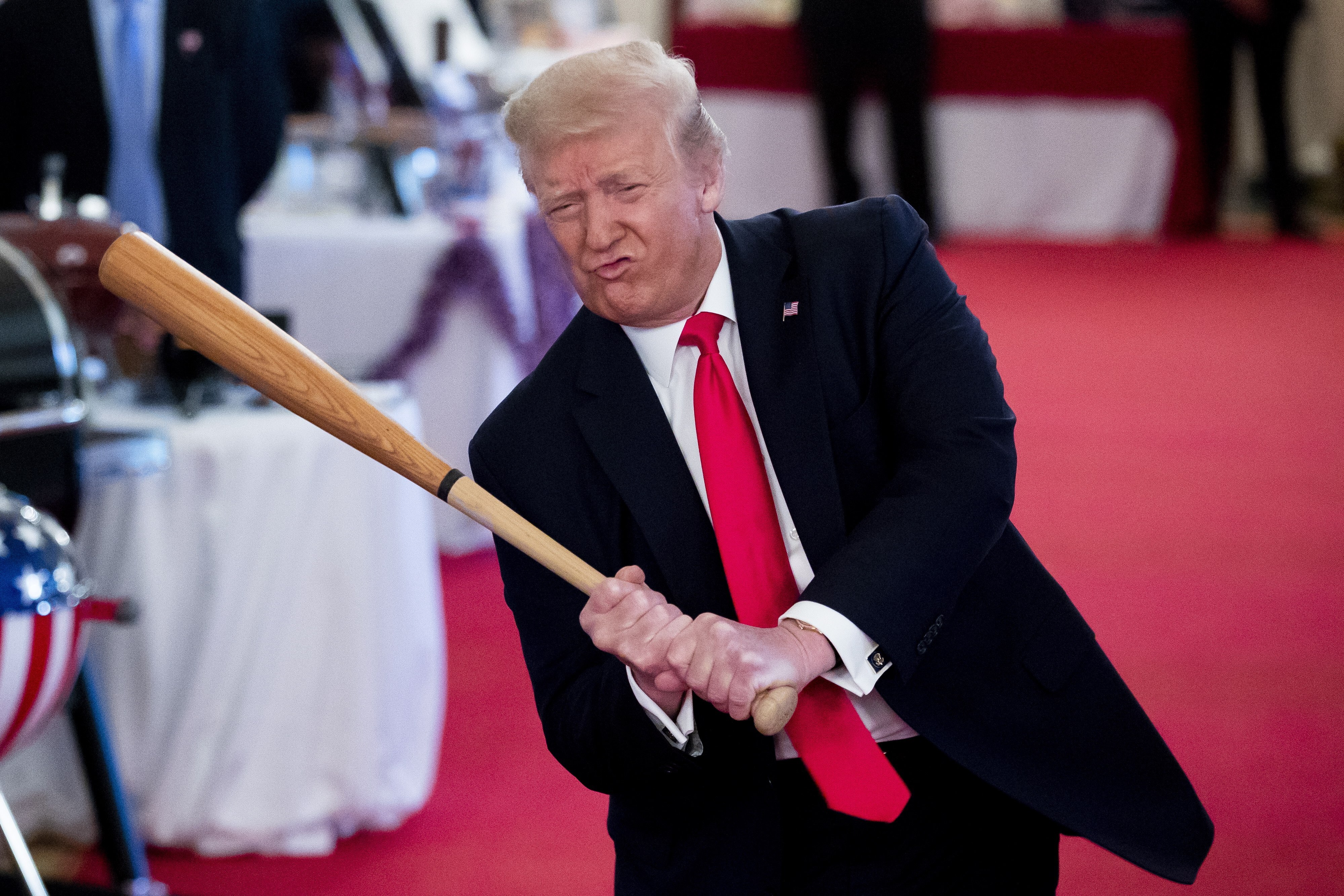 US President Donald Trump swings a baseball bat at the White House in  July 2020. Photo: EPA