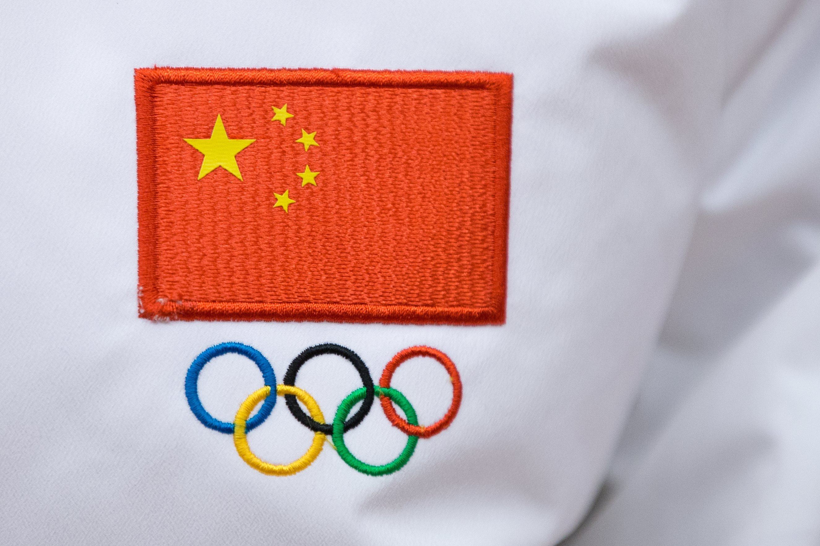 A Chinese flag and Olympic sign are seen on a jacket worn by a Chinese sportsman during a ceremony in Beijing in 2018. Photo: EPA