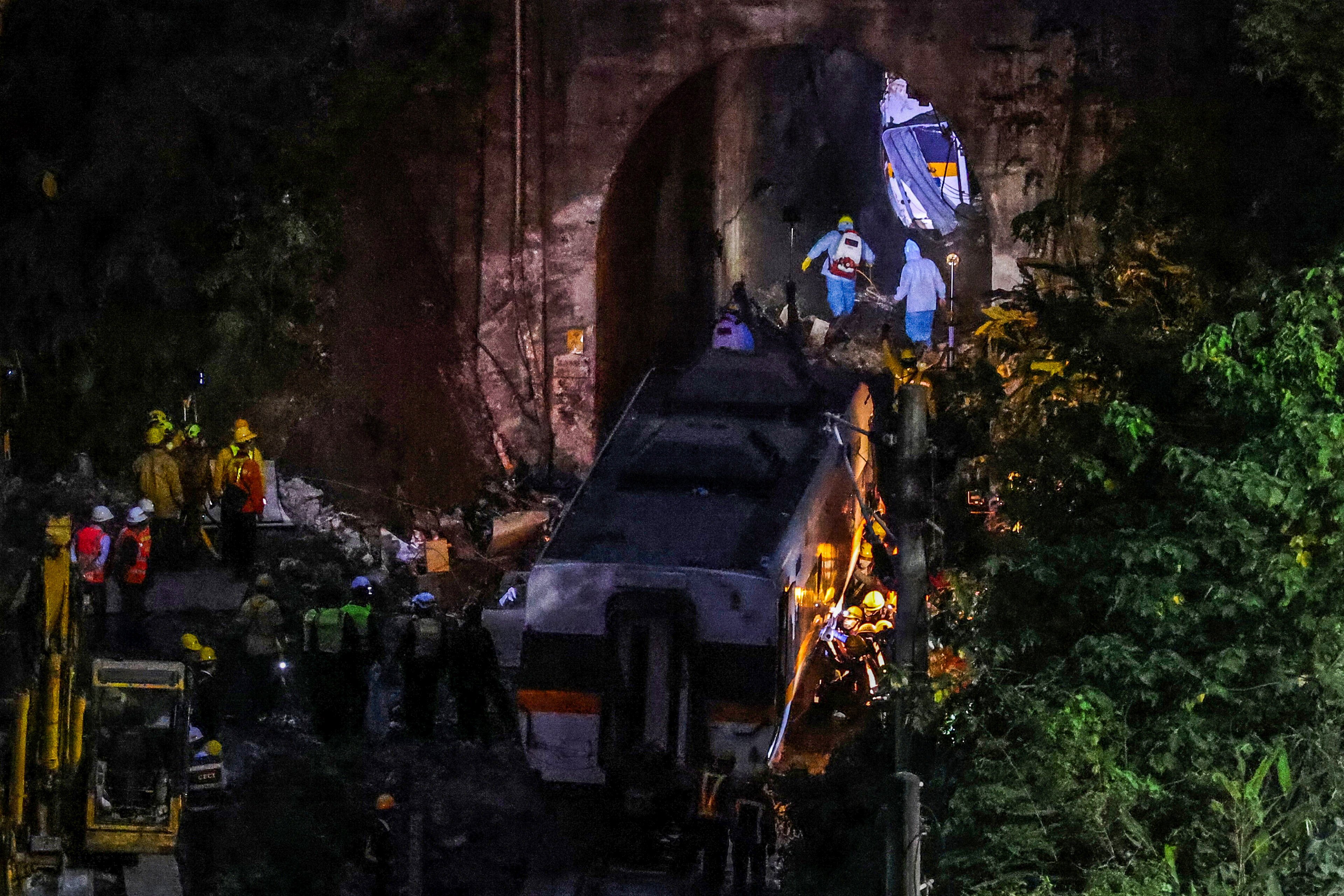 Staff in personal protective equipment work inside the tunnel where the deadly train derailment occurred, north of Hualien, Taiwan. Photo: Reuters