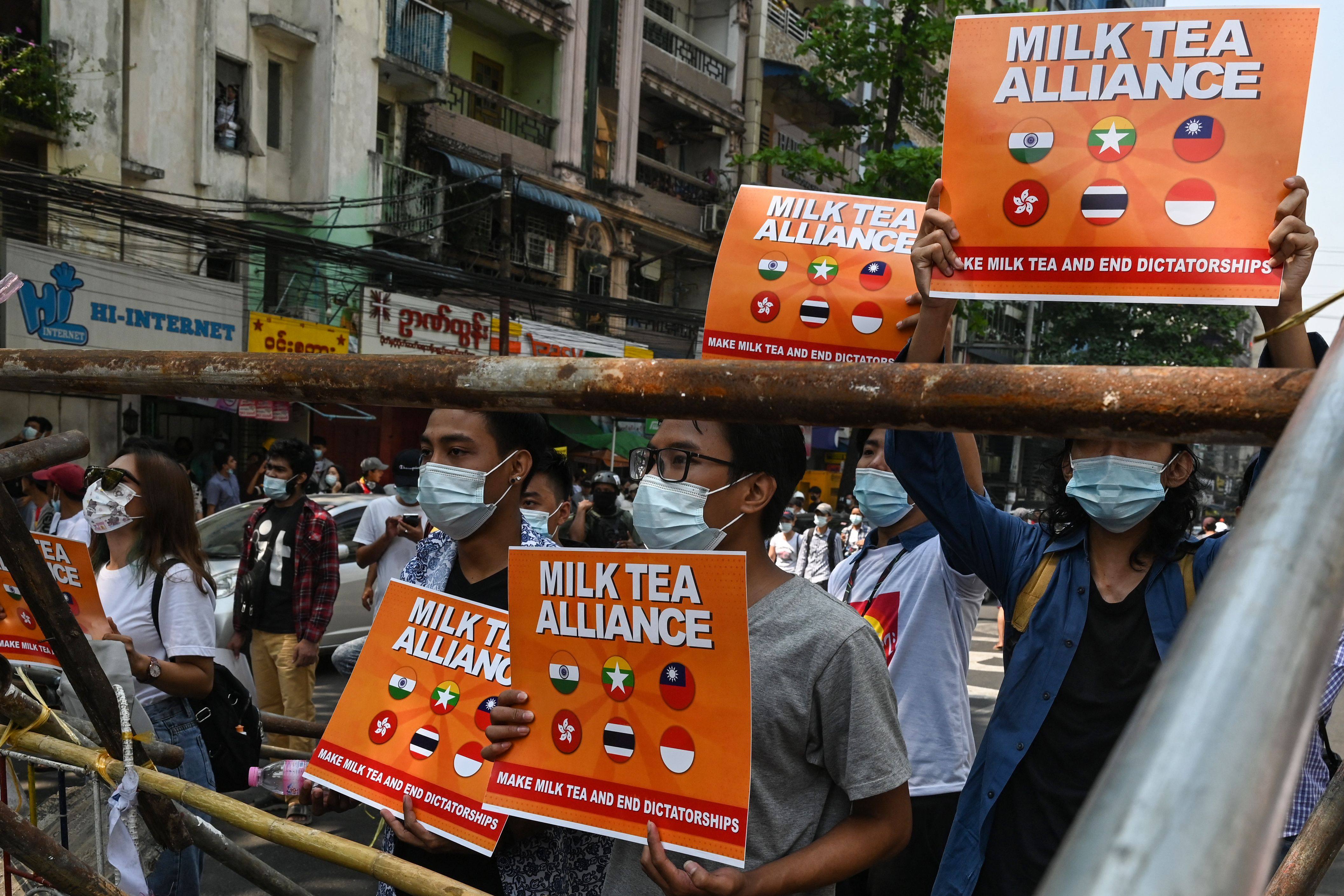 Protesters hold signs hailing the Milk Tea Alliance during a demonstration against the military coup in Yangon. Photo: Myanmar