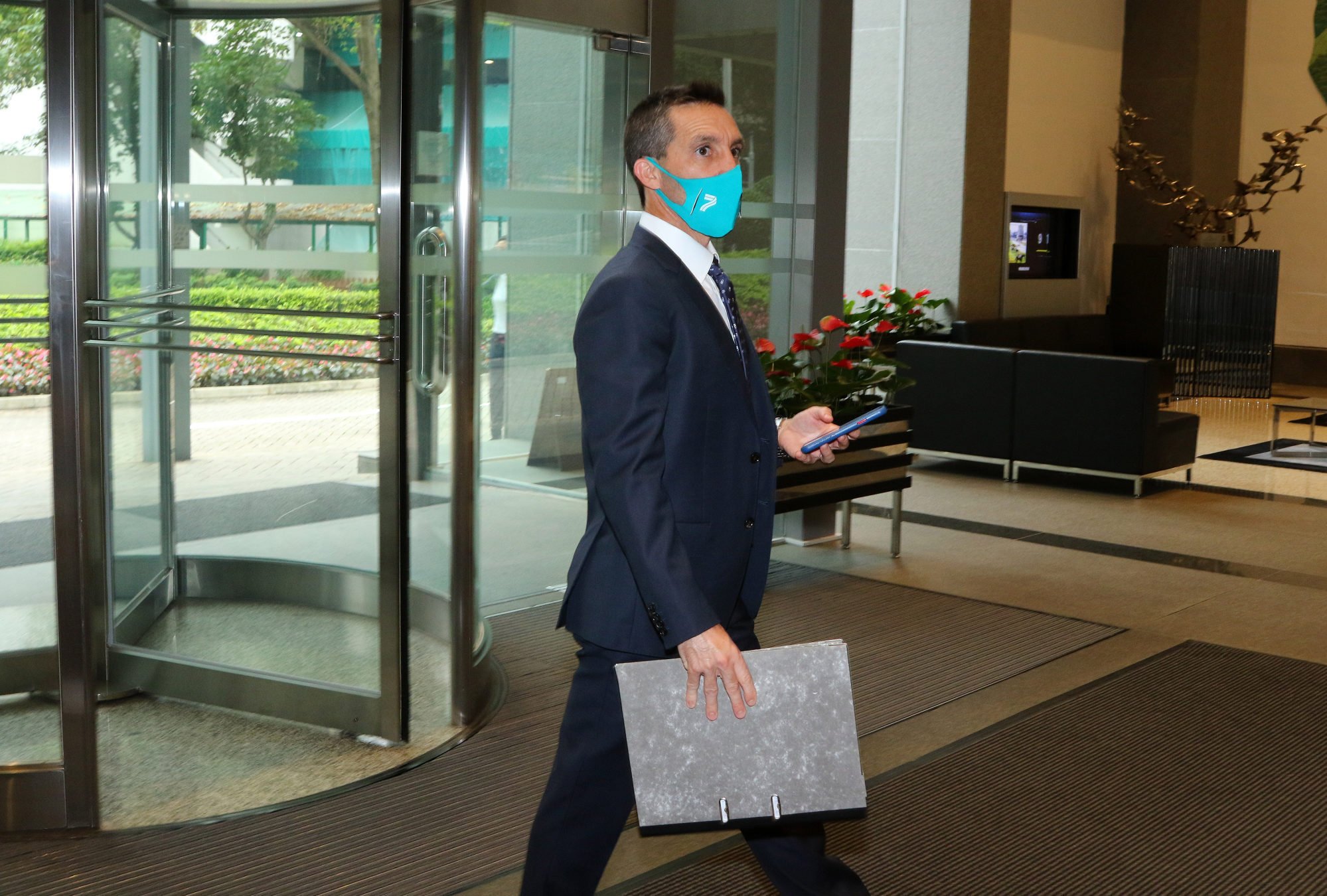 Jockey Neil Callan enters HKJC headquarters for his licensing committee hearing.