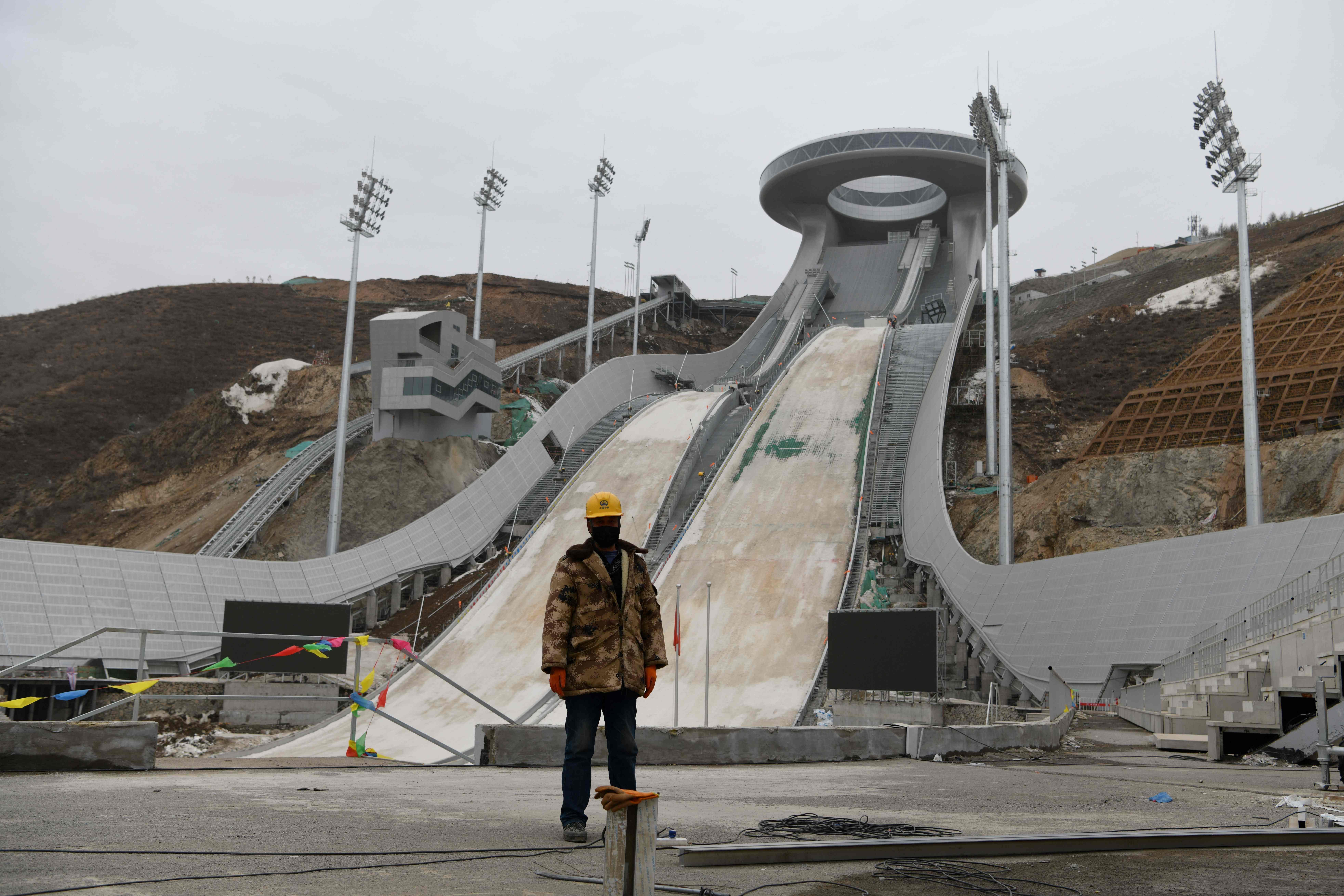 A worker stands at the base of the under-construction ski jumping venue for the 2022 Beijing Winter Olympic Games in Zhangjiakou, 200km northwest of Beijing, on March 17. Photo: AFP