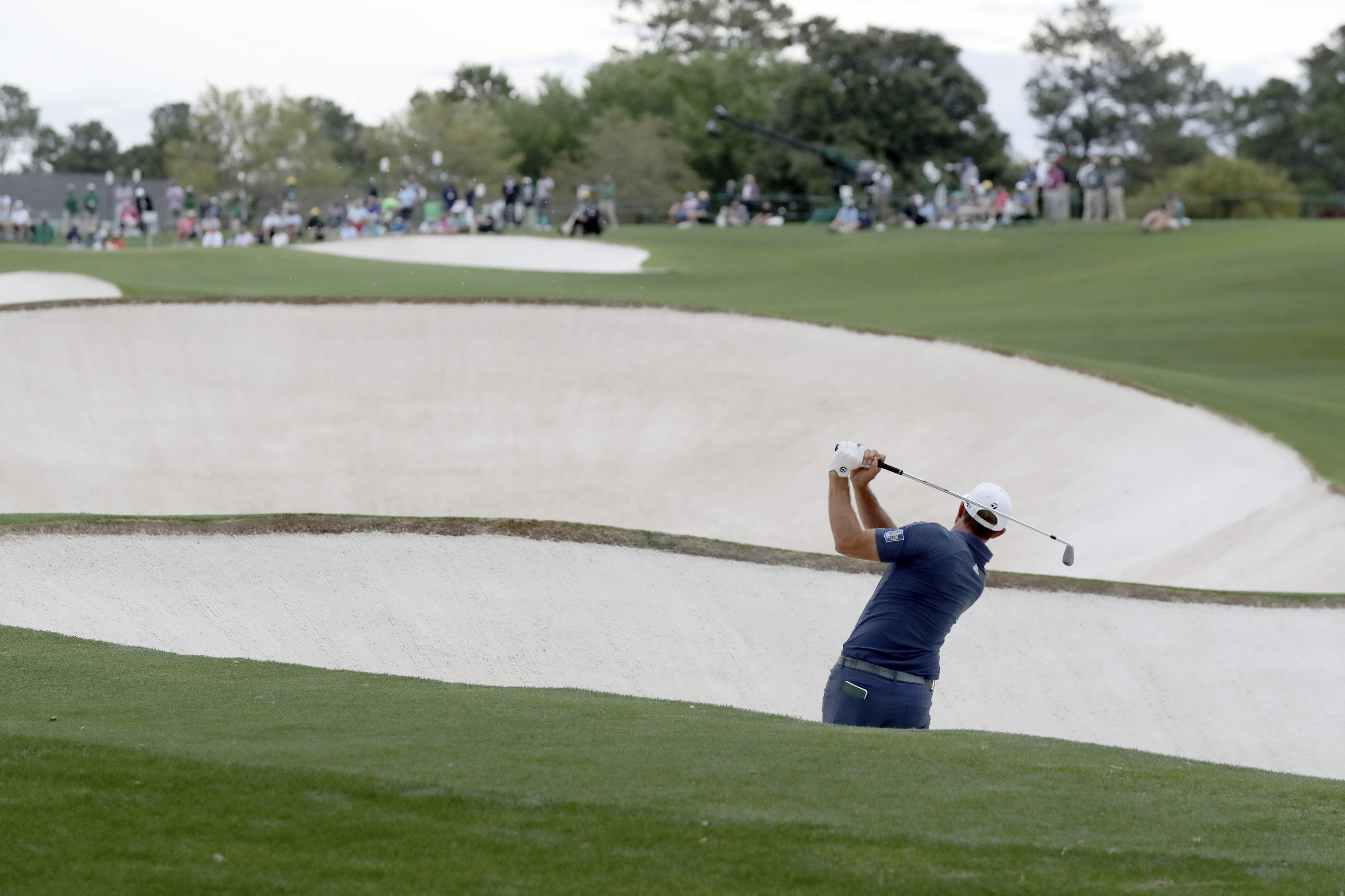 Dustin Johnson hits out of a bunker on the 18th hole during the second round of the 2021 Masters at Augusta National. Photo: AP