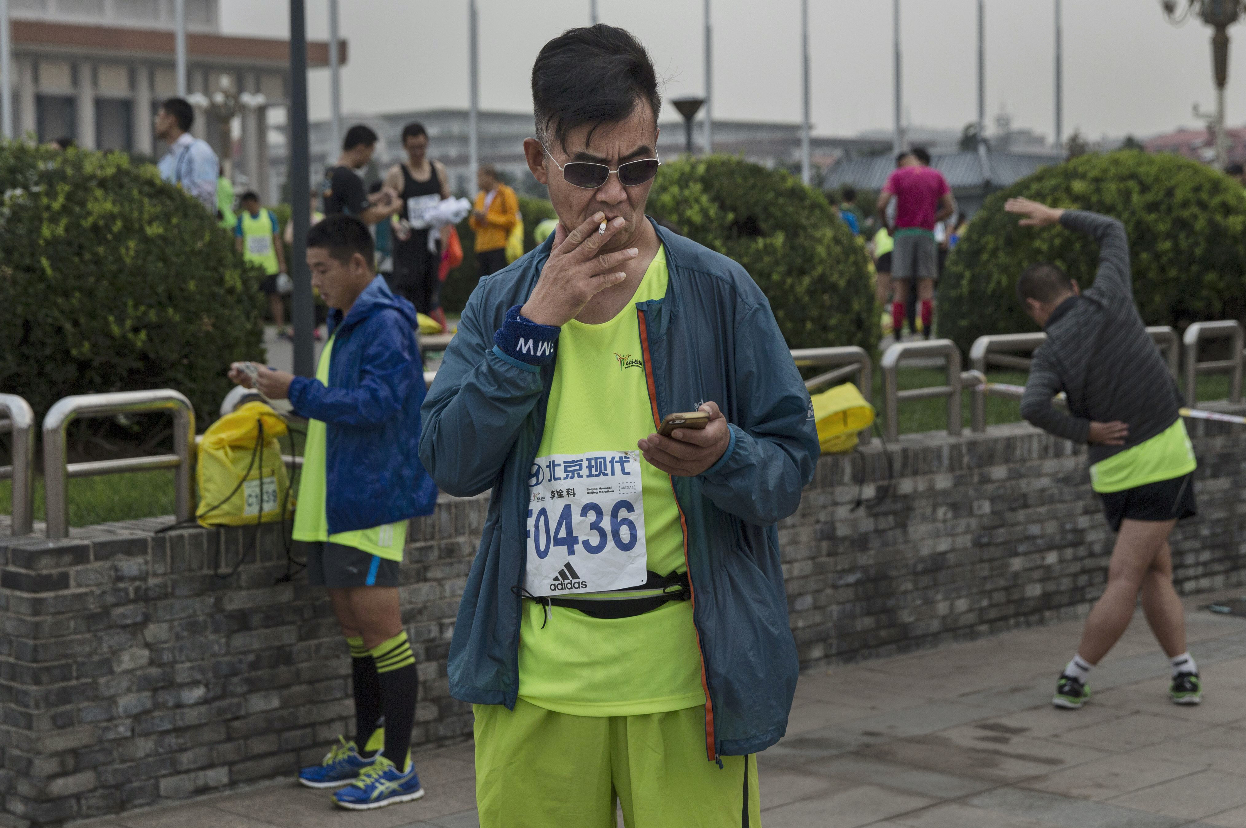 A Chinese runner smokes a cigarette before competing in the 2015 Beijing Marathon. Lung cancer is the deadliest in China. Photo: Getty Images