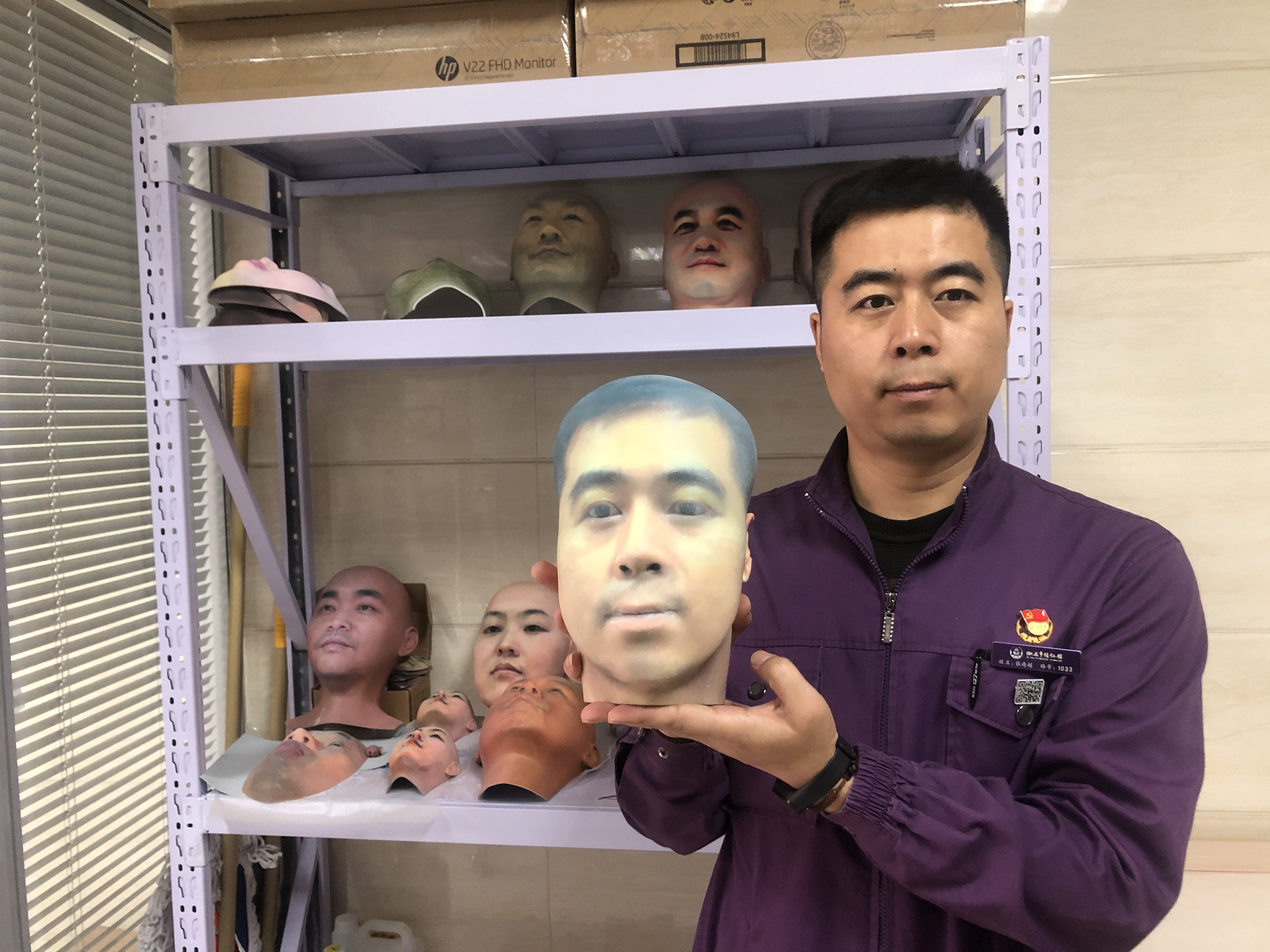Zhang Lianchao, a staff member at the Xian Funeral Home, holds up a mask of his face printed using 3D printing technology. Photo: Zhang Lianchao