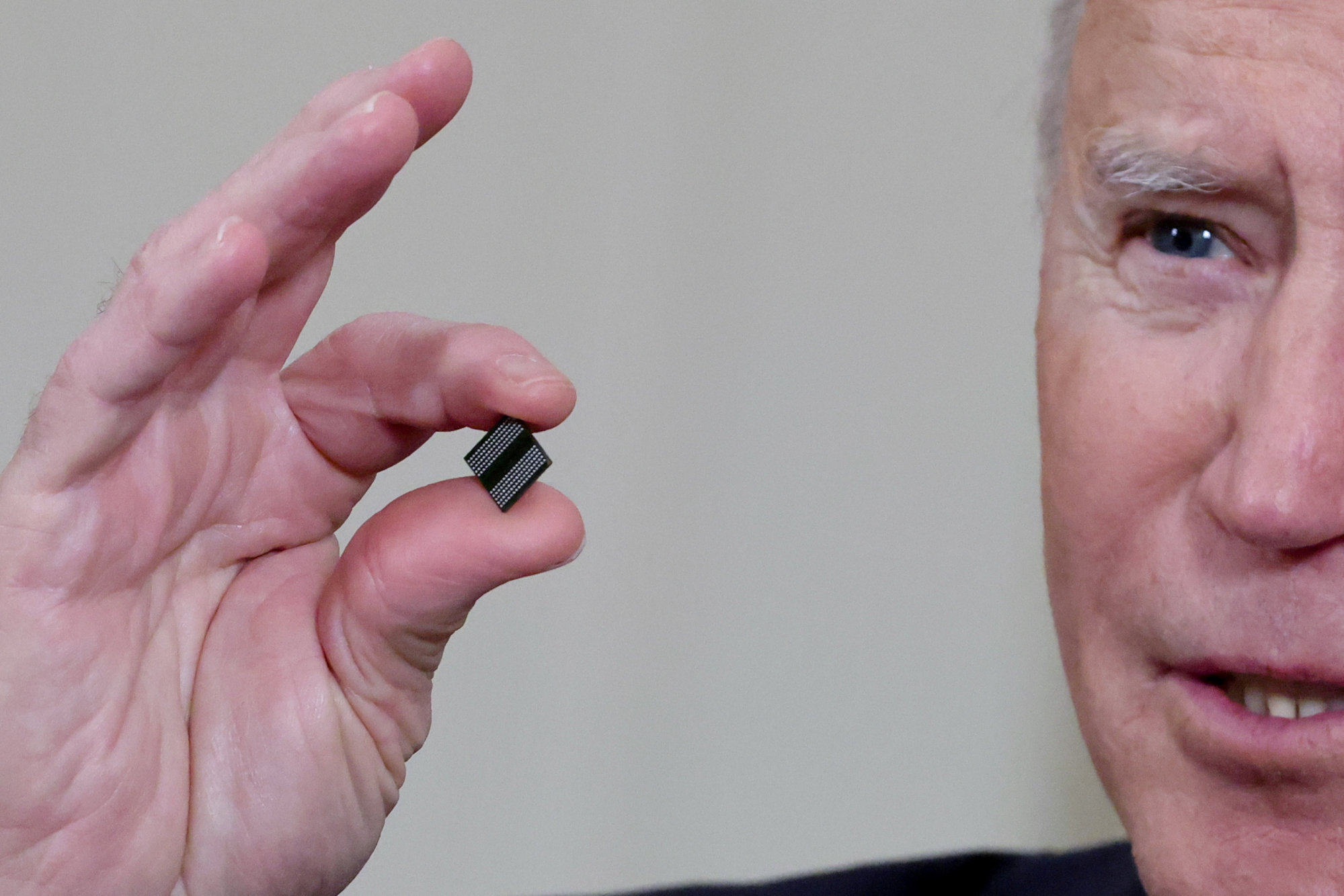 US President Joe Biden holds a semiconductor chip as he speaks before signing an executive order, aimed at addressing a global semiconductor chip shortage, in the State Dining Room at the White House in Washington, US, on February 24, 2021. Photo: Reuters
