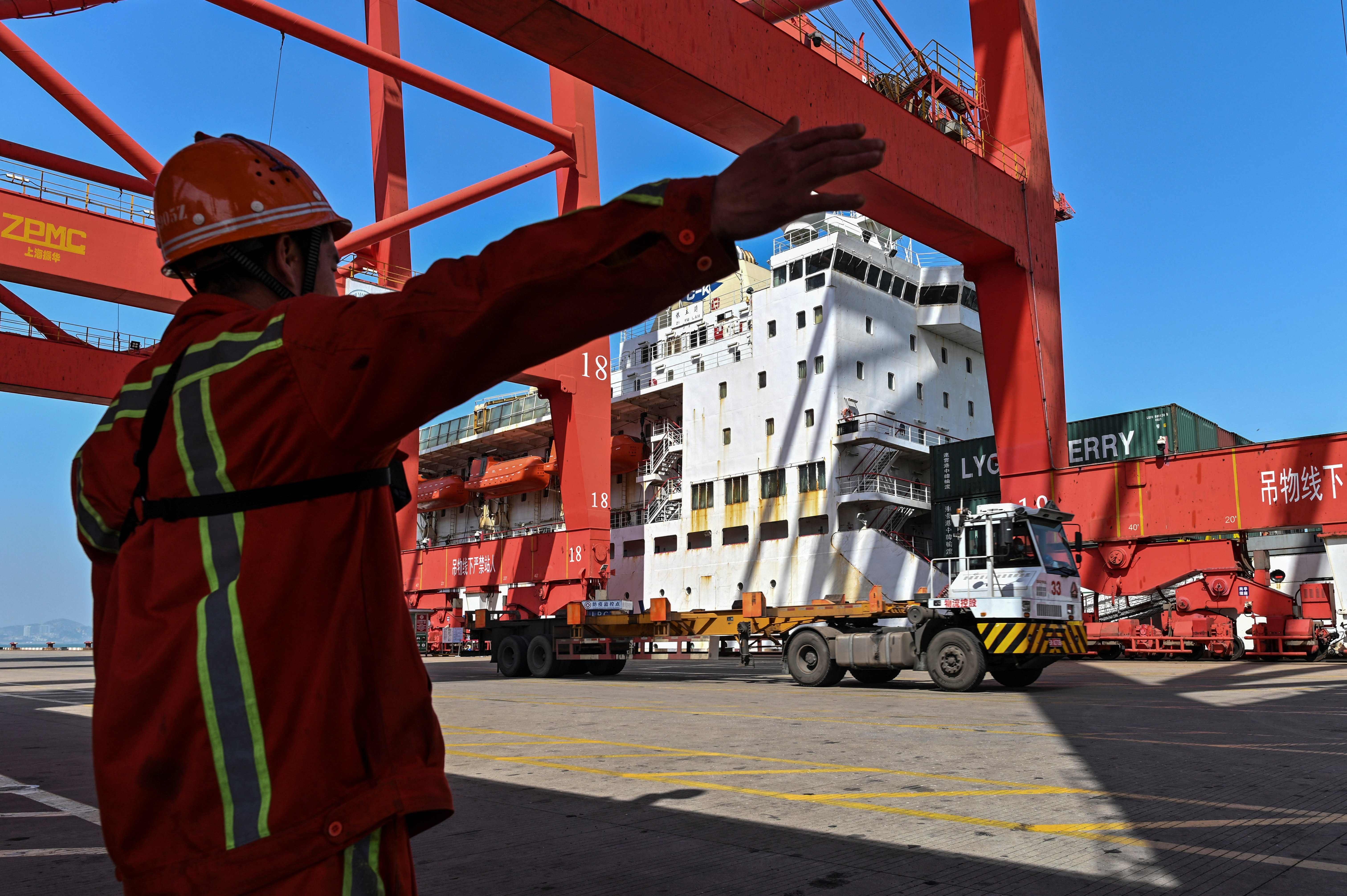 A worker gestures while a crane prepares to load a container onto a truck in Lianyungang, Jiangsu province on March 24. China’s exports rose in March as demand picked up in key overseas markets, including the US. Photo: AFP