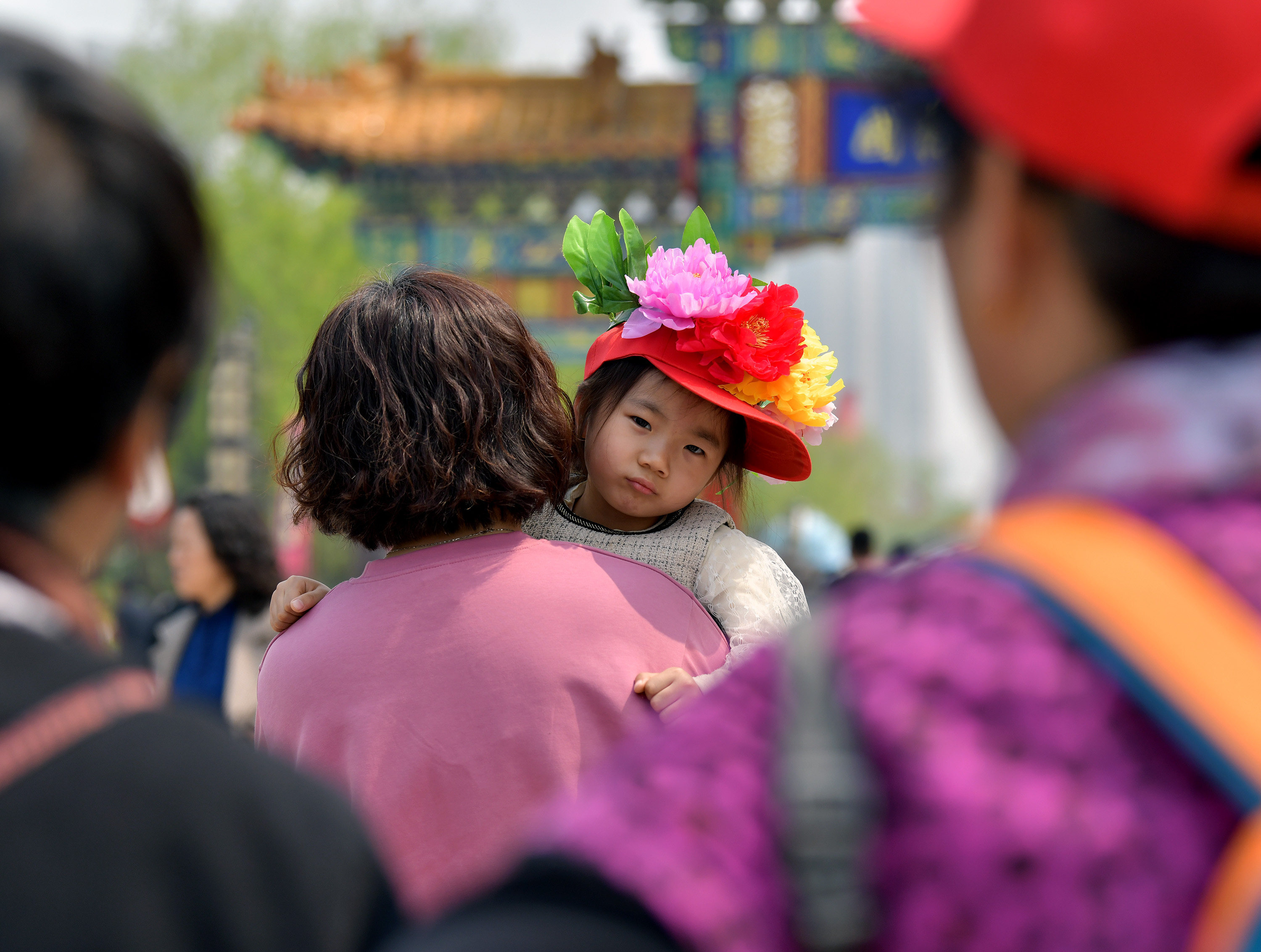 A girl wearing peony decorations visits a garden in Heze city, Shandong province, on April 8. Gender stereotypes can have an impact on a daughter’s educational achievement, which is usually a precondition for economic achievement. Photo: Xinhua