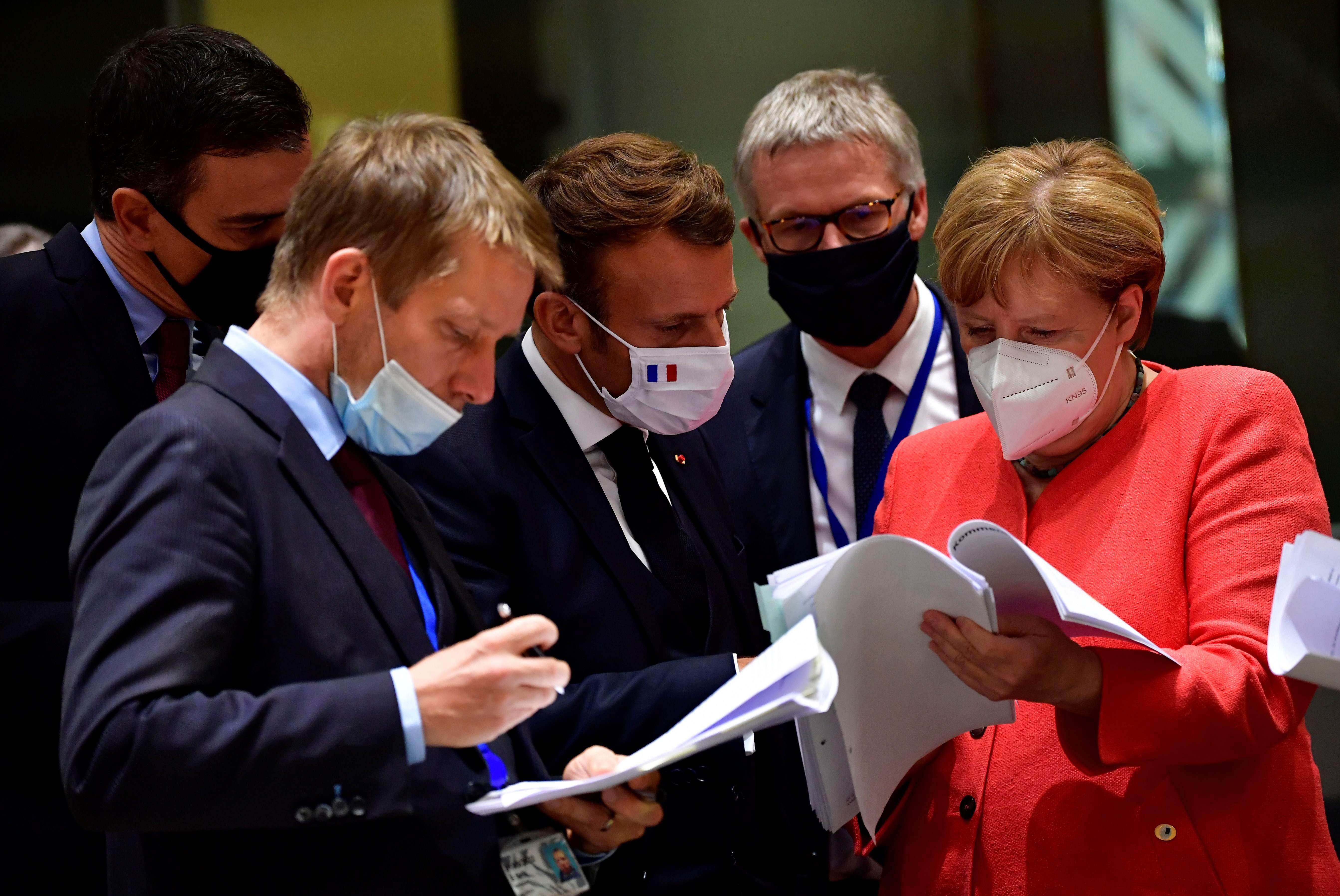 Spanish Prime Minister Pedro Sanchez (left), French President Emmanuel Macron (centre) and German Chancellor Angela Merkel (right) examine documents during an EU summit in Brussels last July. Photo: AFP