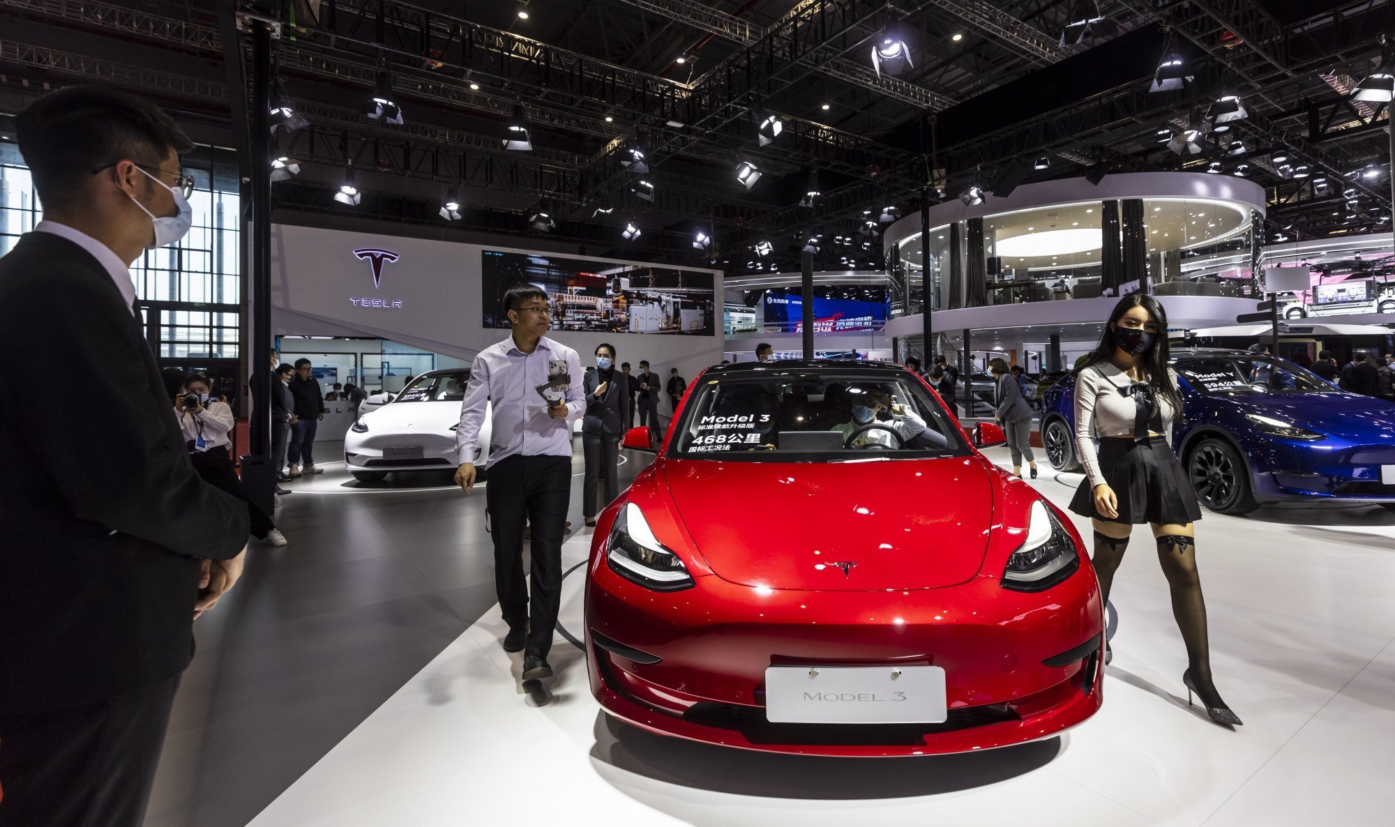 People walk by the Tesla Model 3 car at the Auto Shanghai 2021 motor show in Shanghai, China, 19 April 2021. Photo: EPA-EFE 