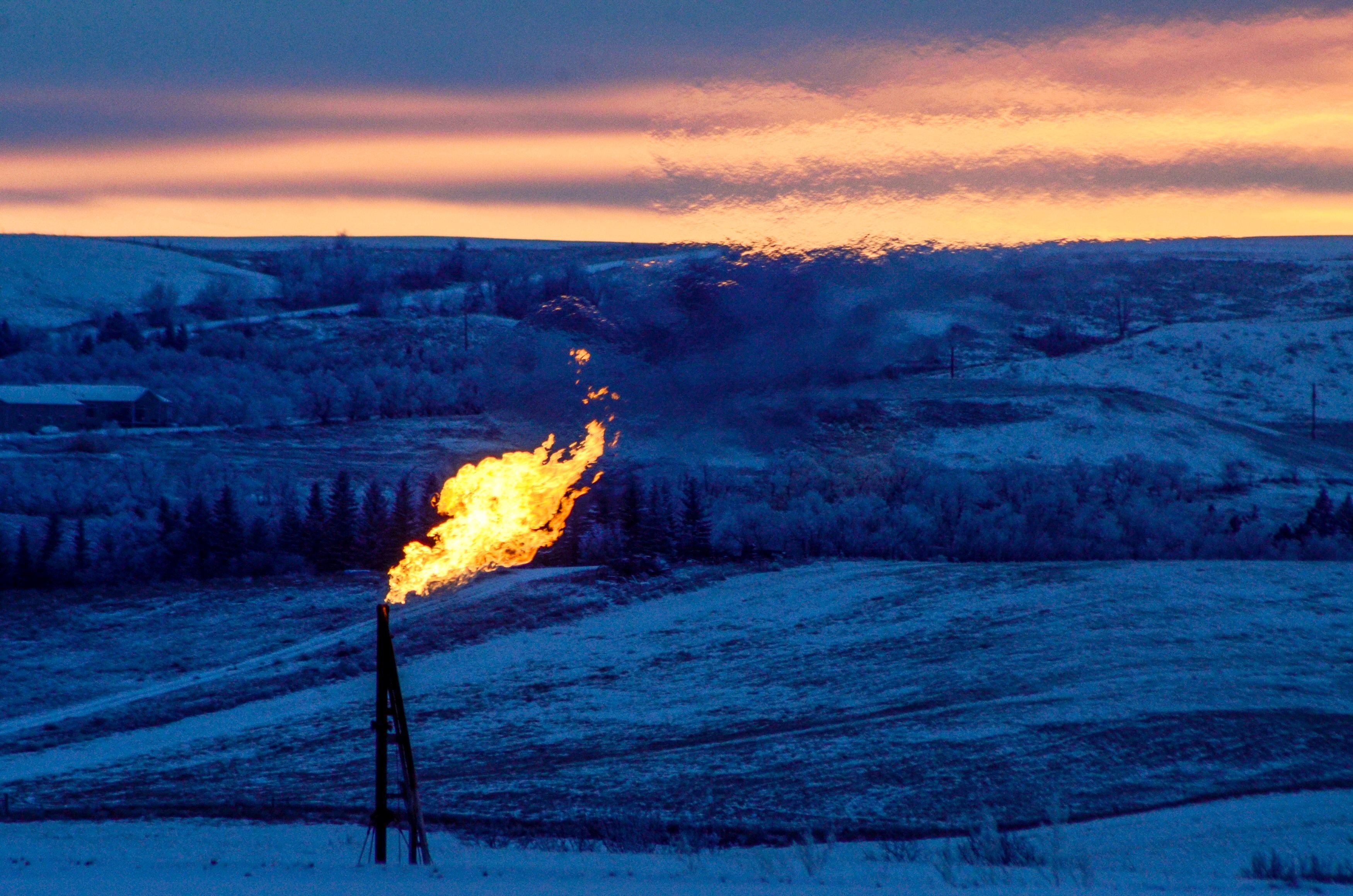A natural gas flare on an oil well pad burns as the sun sets outside Watford City, North Dakota, on January 21, 2016. Photo: Reuters
