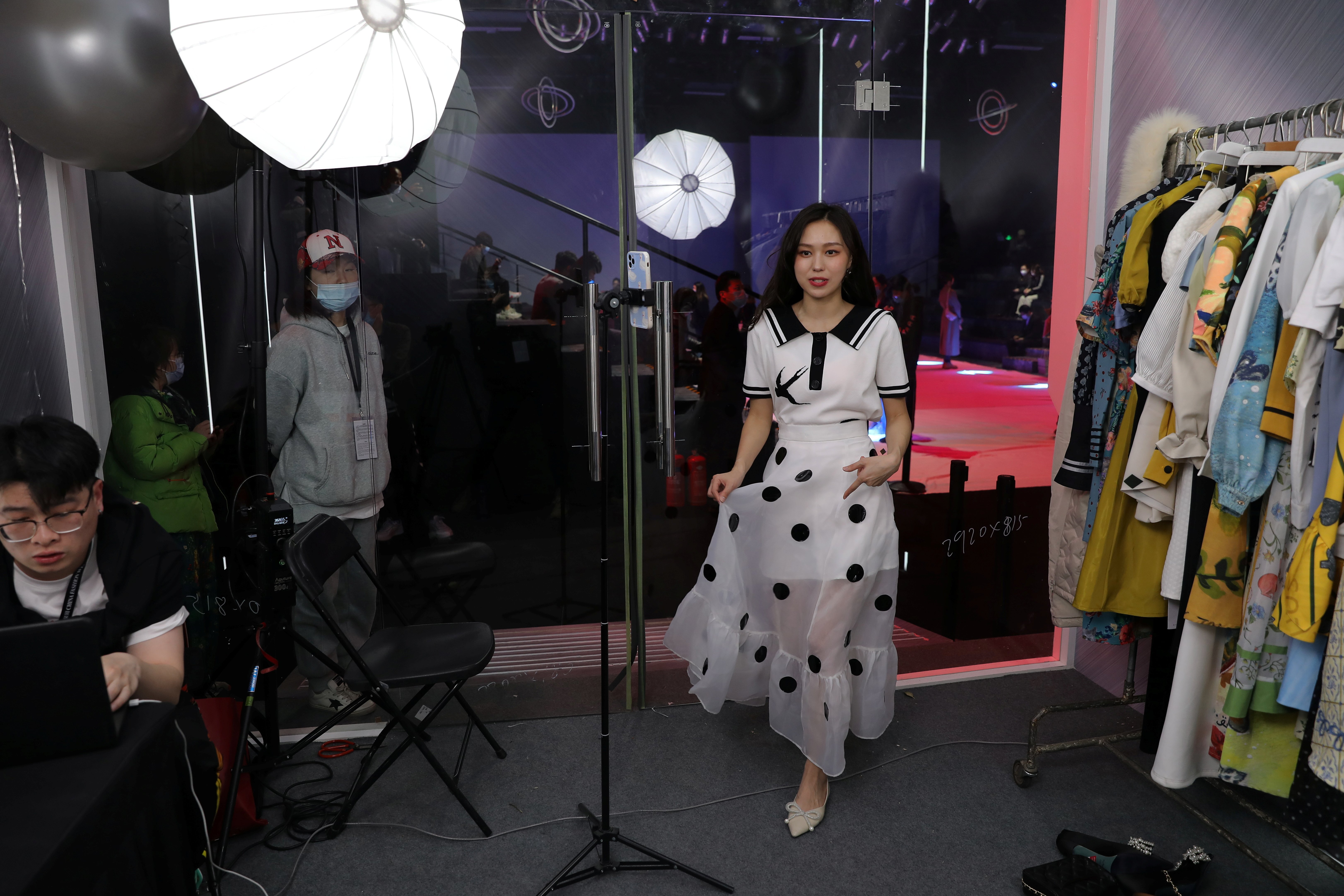 A live streamer promotes a dress during a live-streaming session, inside a booth set up at a show venue during China Fashion Week in Beijing, China, on March 31, 2021. Photo: Reuters