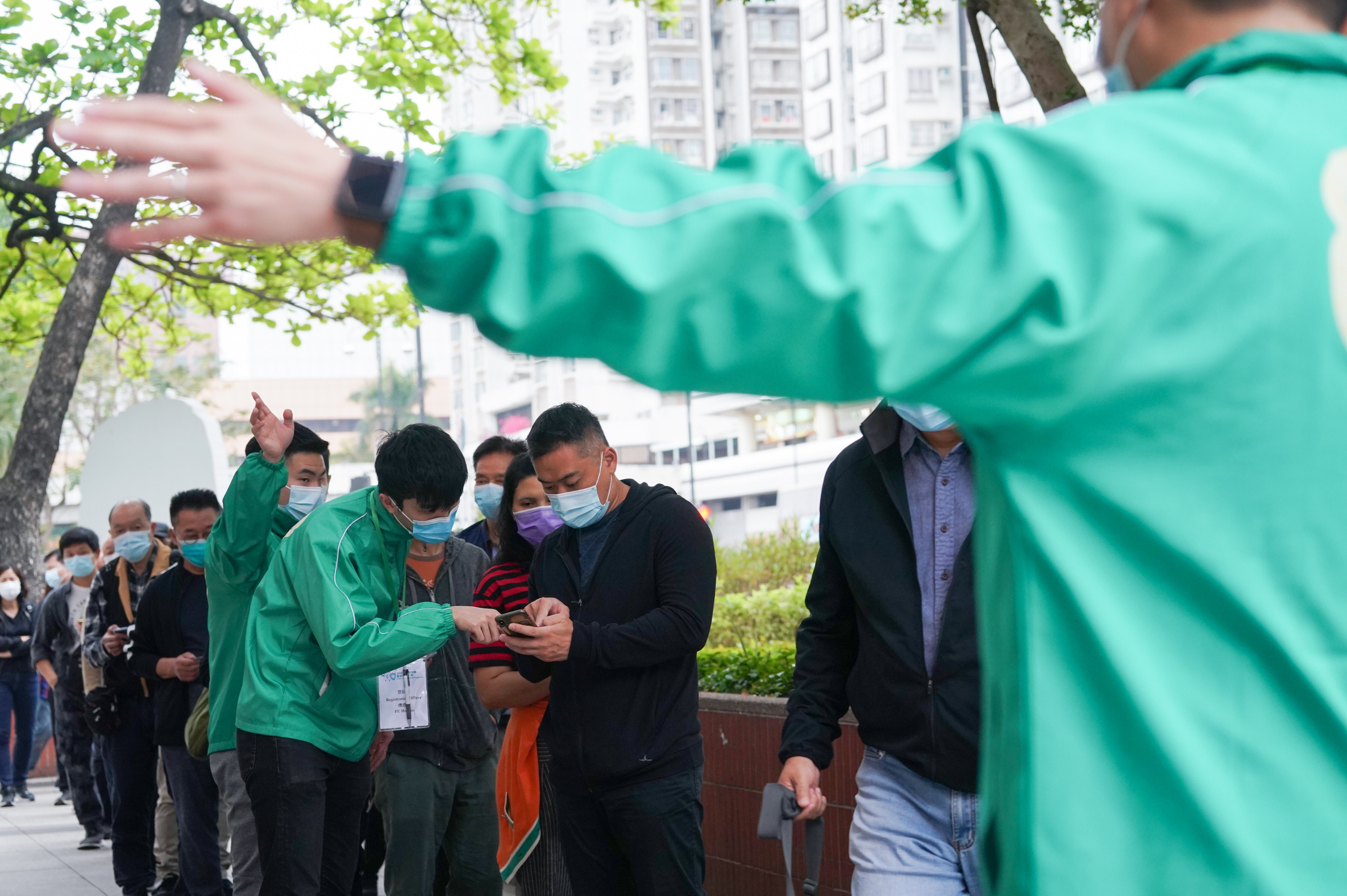 Workers manage the queue outside the Sha Tin Community Vaccination Centre on March 27. Photo: Felix Wong