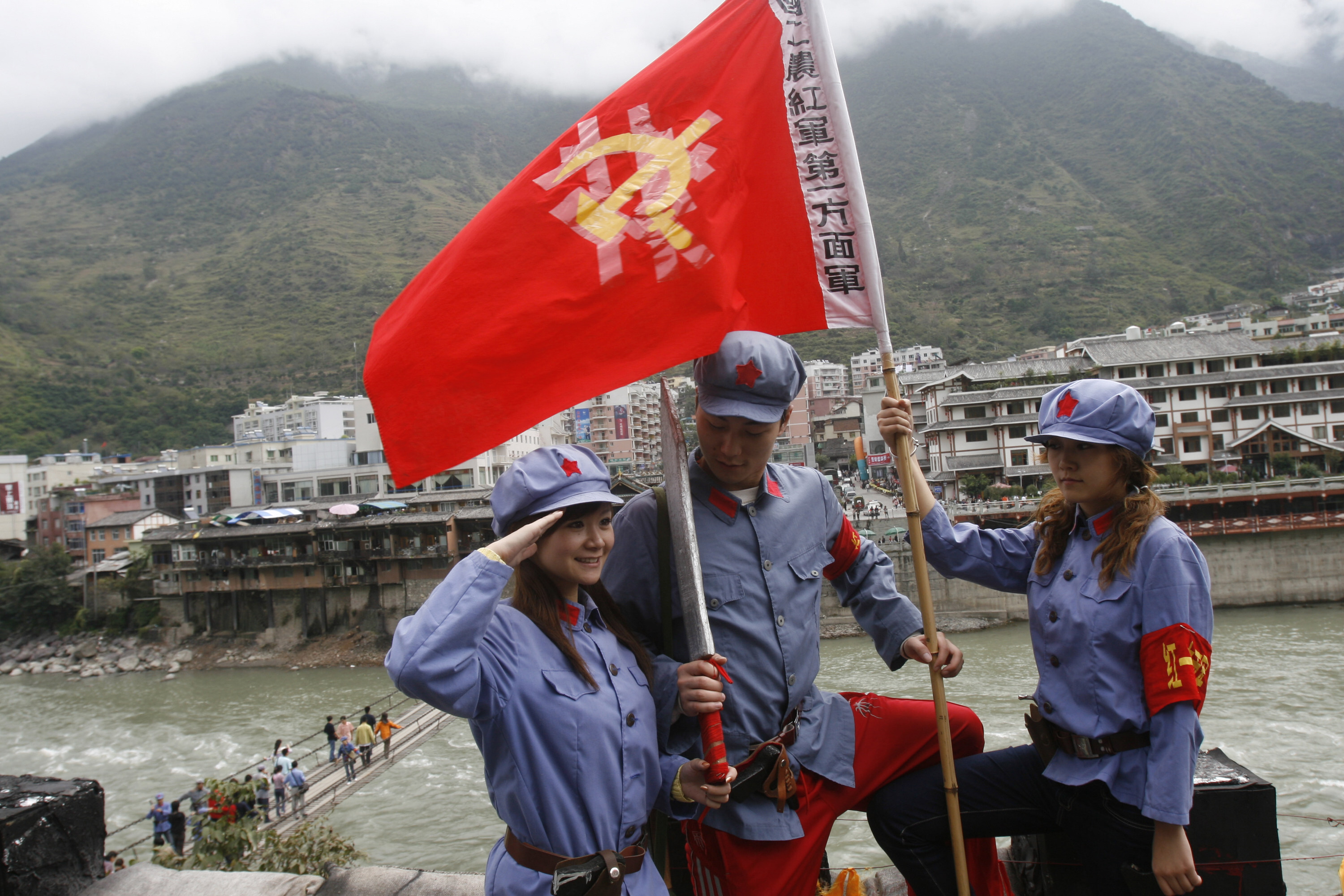 Chinese tourists take photos of themselves wearing Red Army costumes as they visit the hanging bridge in the city of Luding, site of a famous 1930s civil war skirmish, in Sichuan province. Photo: Getty Images