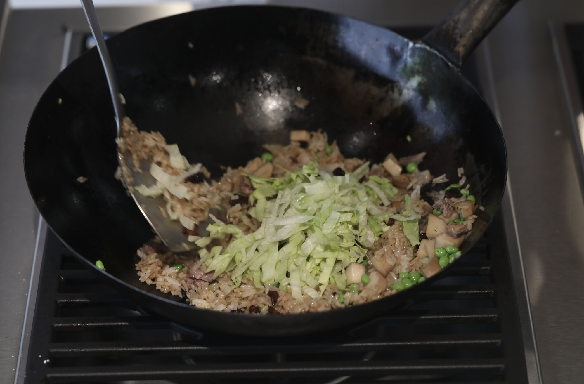 Mix in the shredded lettuce and stir until it wilts. Photo: Jonathan Wong