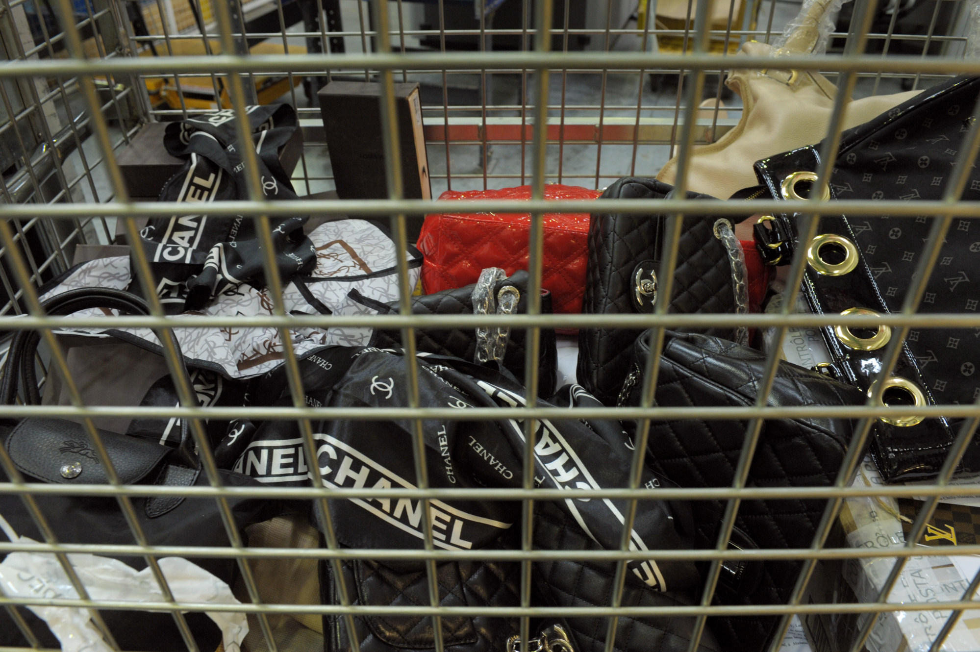 Counterfeit Chanel, Yves Saint Laurent and Louis Vuitton handbags seized by French customs before their destruction in May 2012 at the postal sorting centre of Chilly Mazarin, near Paris. Photo: AFP/GettyImages