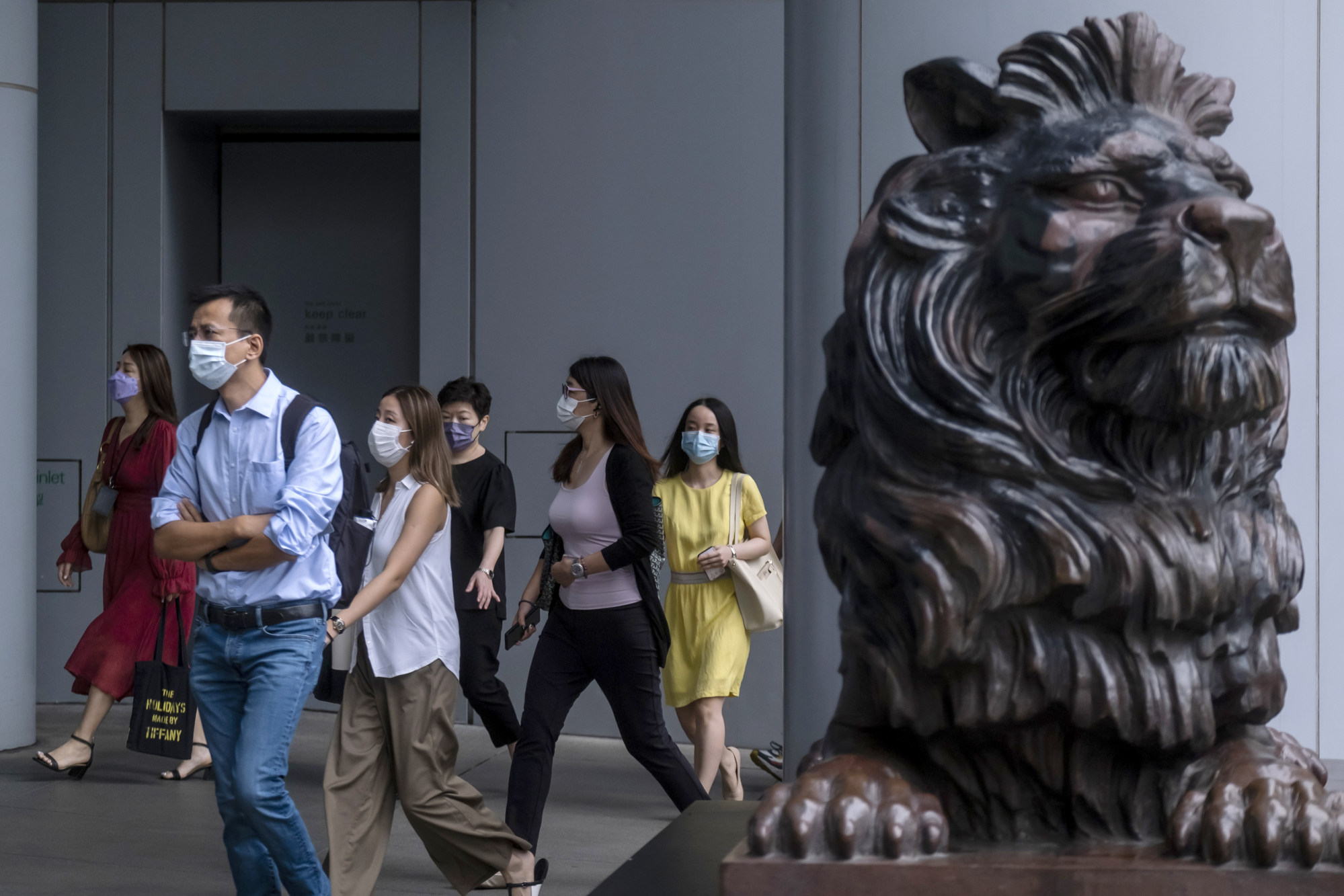 Commuters walk underneath HSBC’s headquarters in the Central district of Hong Kong. The bank is one of three authorised banknote issuers in the city. Photo: Bloomberg
