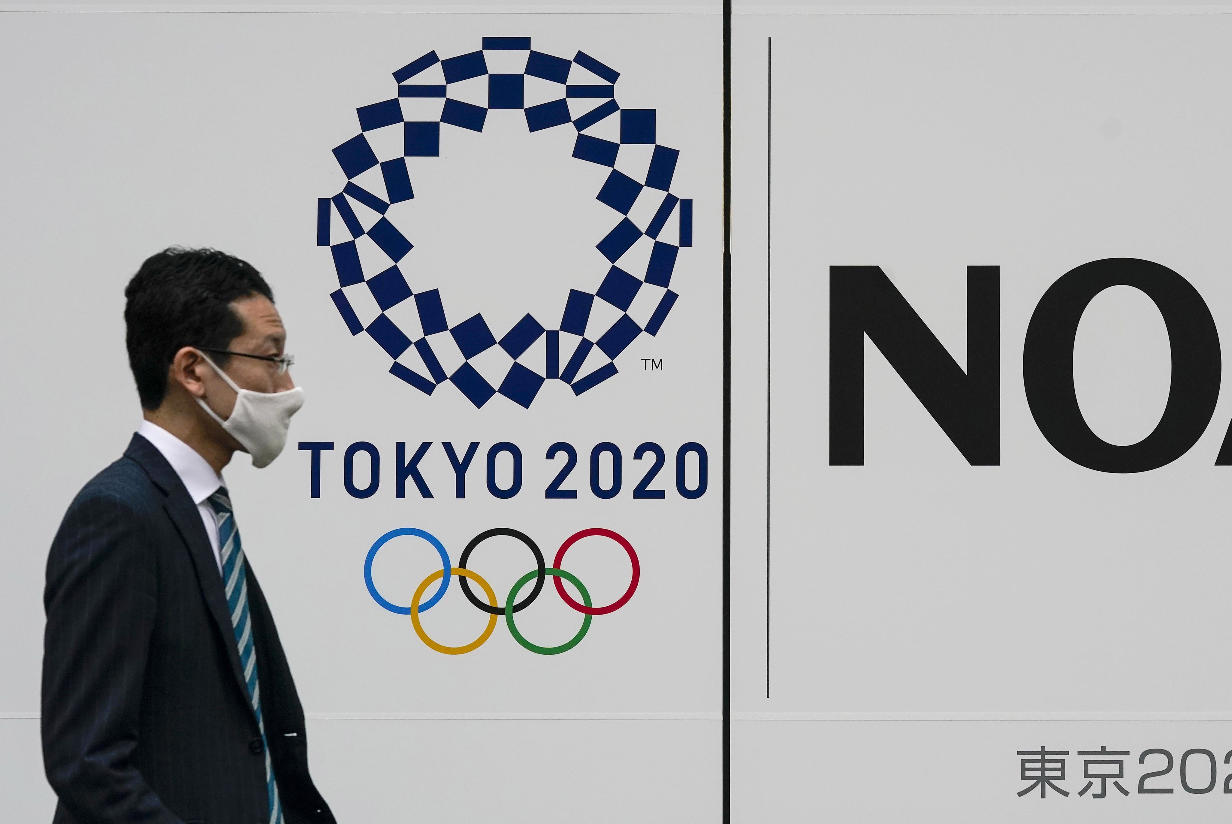 A pedestrian walks past the logo of Tokyo 2020 Olympic Games in Tokyo, Japan, Photo: EPA