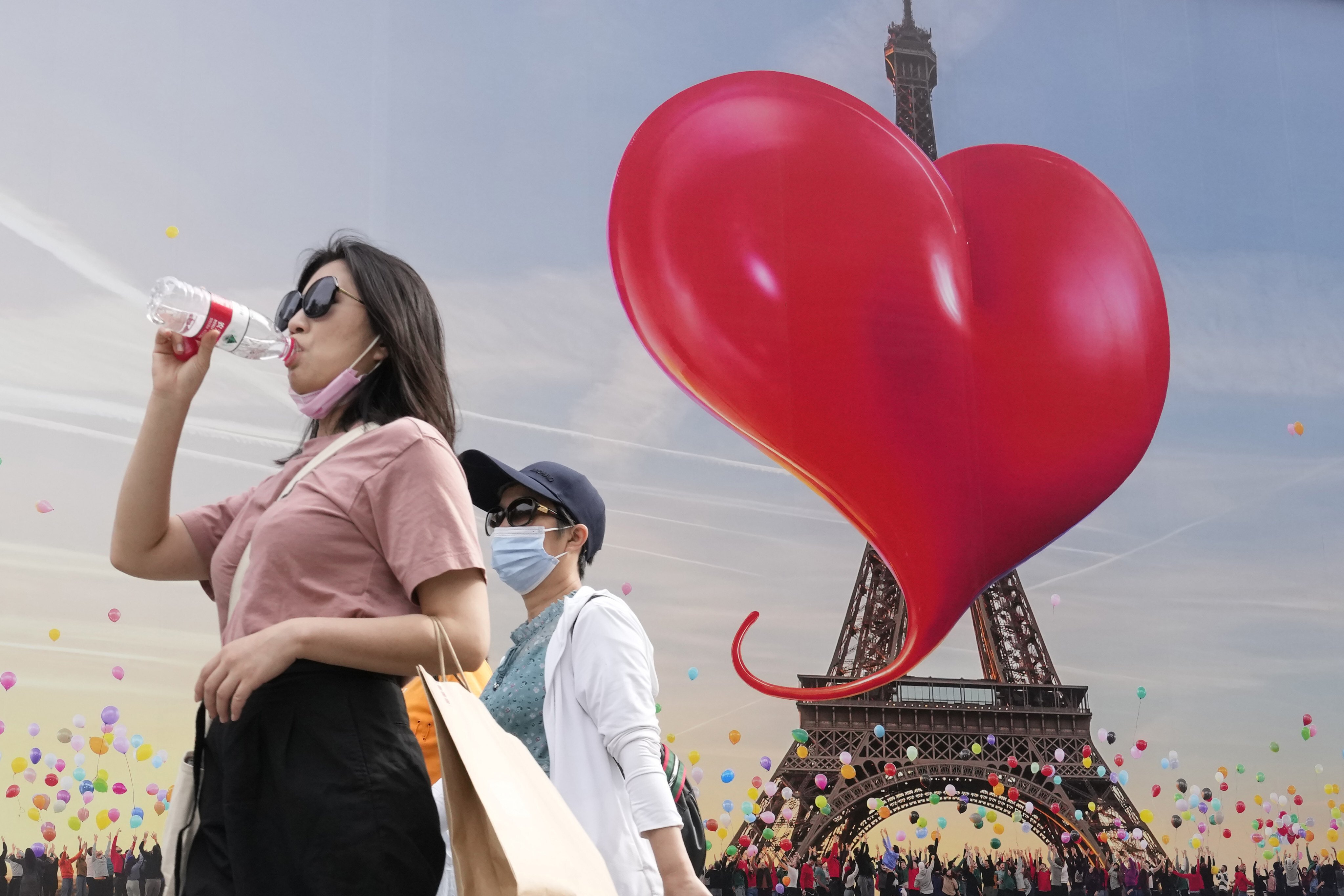 People walk past an advertisement in Beijing featuring a giant heart, on June 11. China’s mission to win friends and influence can begin with creating a narrative that connects with its audience. Photo: AP 