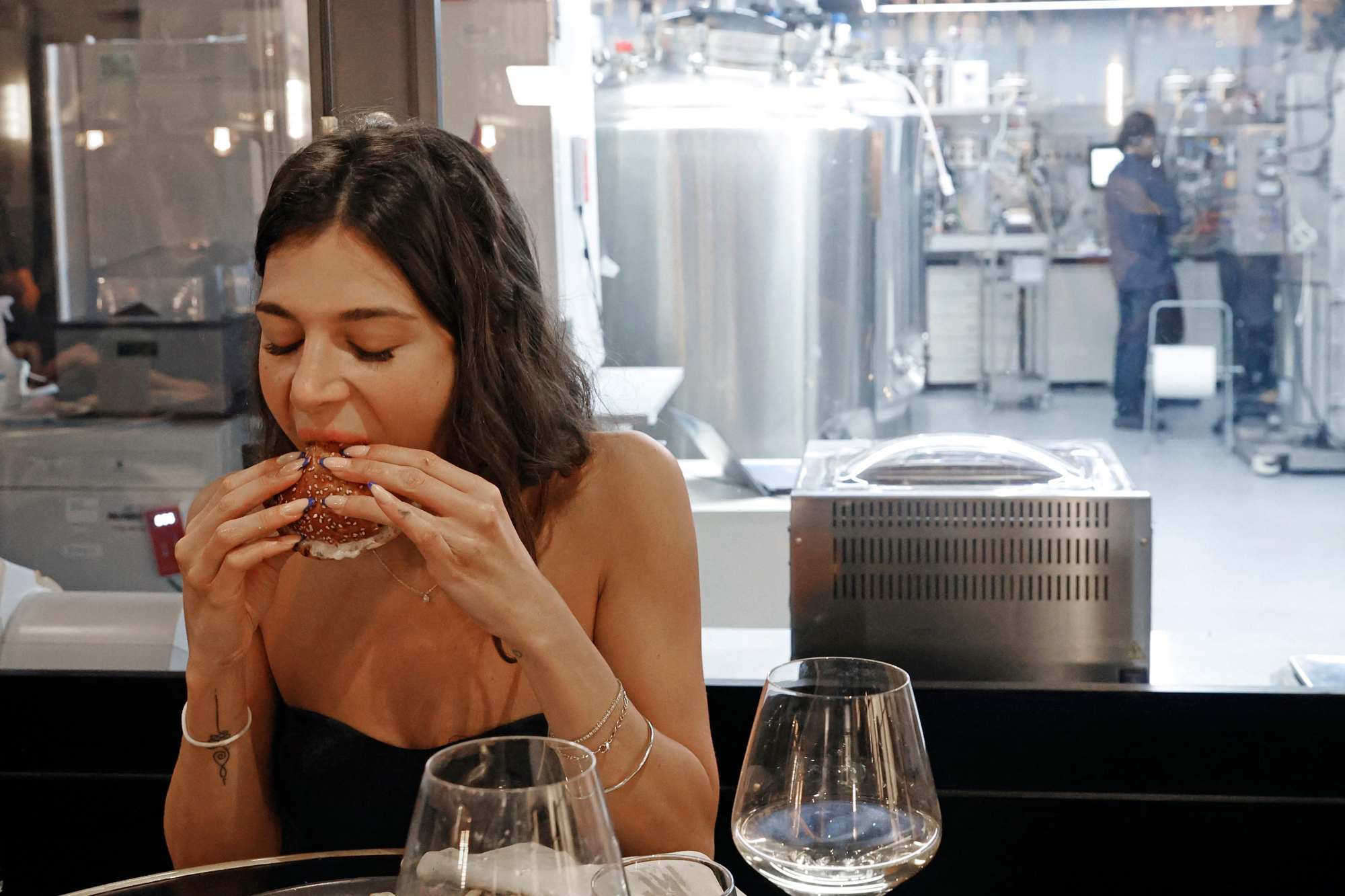 A diner eats a burger made from ‘cultured chicken’ meat at a restaurant adjacent to the SuperMeat production site. Photo: Jack Guez/AFP