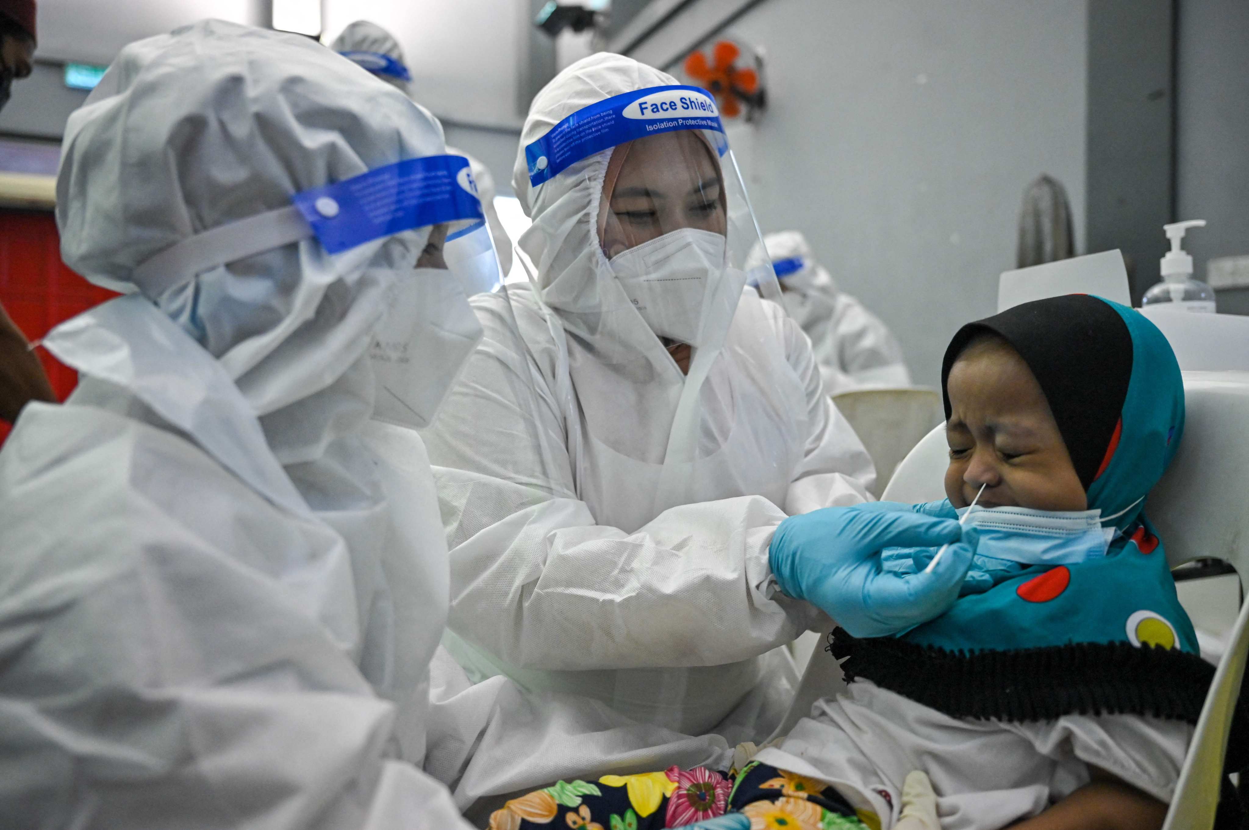 A medical worker tests a child at a free Covid-19 testing site in Shah Alam, on the outskirts of Kuala Lumpur, Malaysia. Photo: AFP
