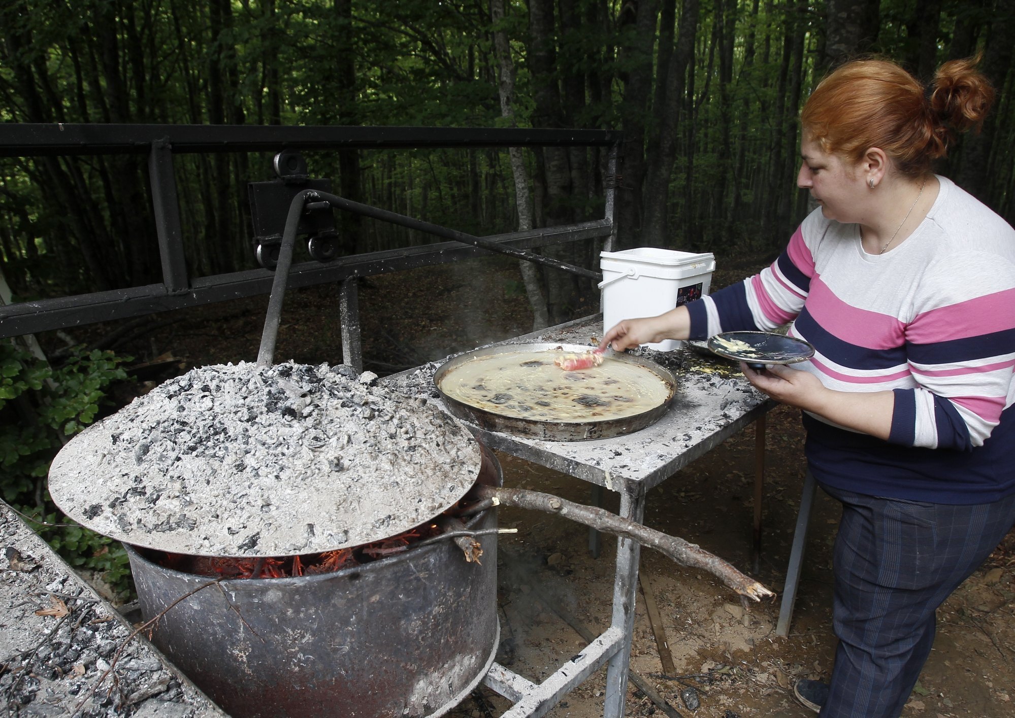 A woman prepares a traditional meal, “flea”, in a farm for mountain tourism on Shar Mountain. Photo: AP