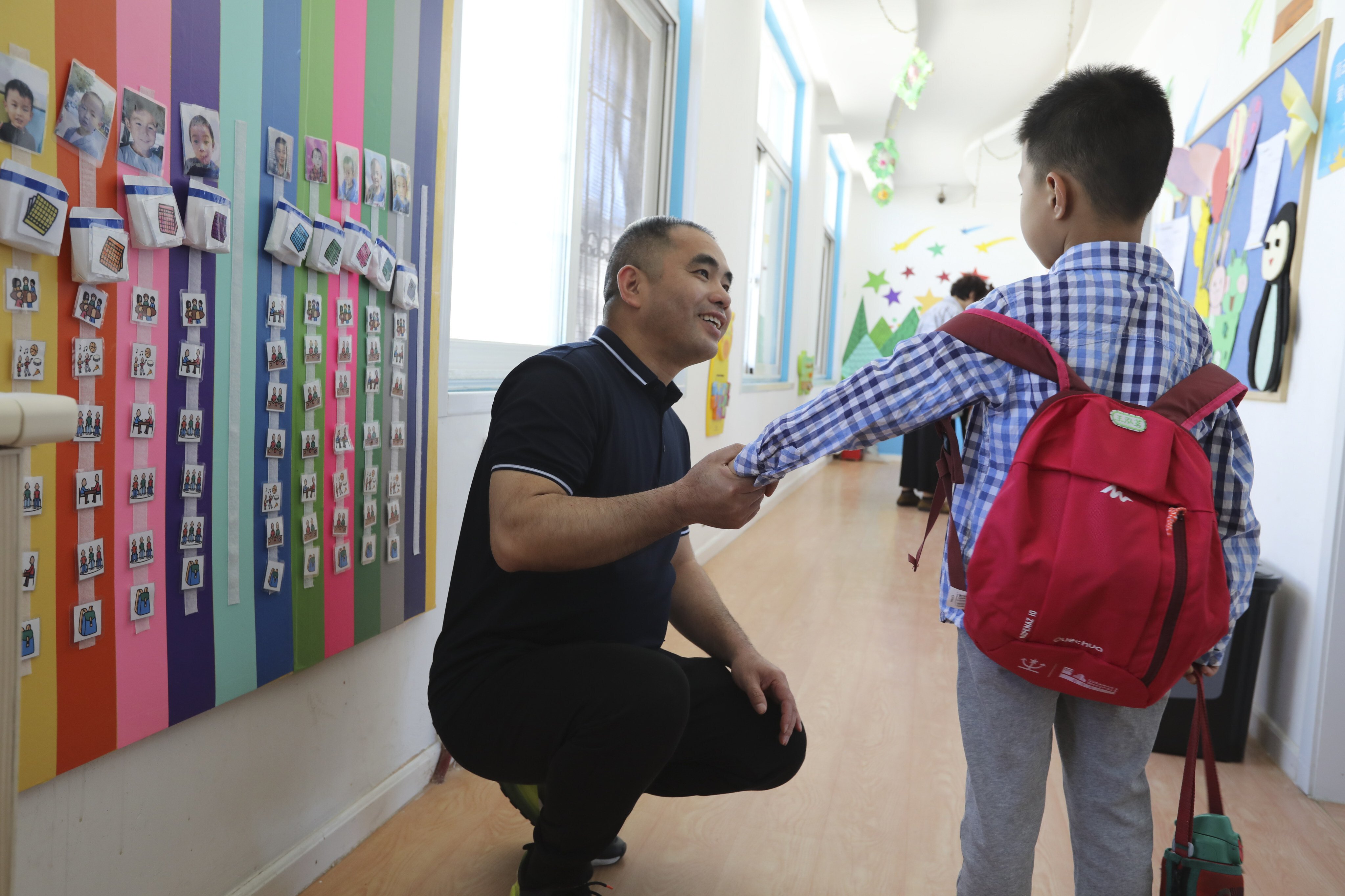 Wu Liangsheng, director for education research at the Beijing Stars and Rain Education Institute for Autism, greets a student at one of the school’s centres. Photo: Simon Song