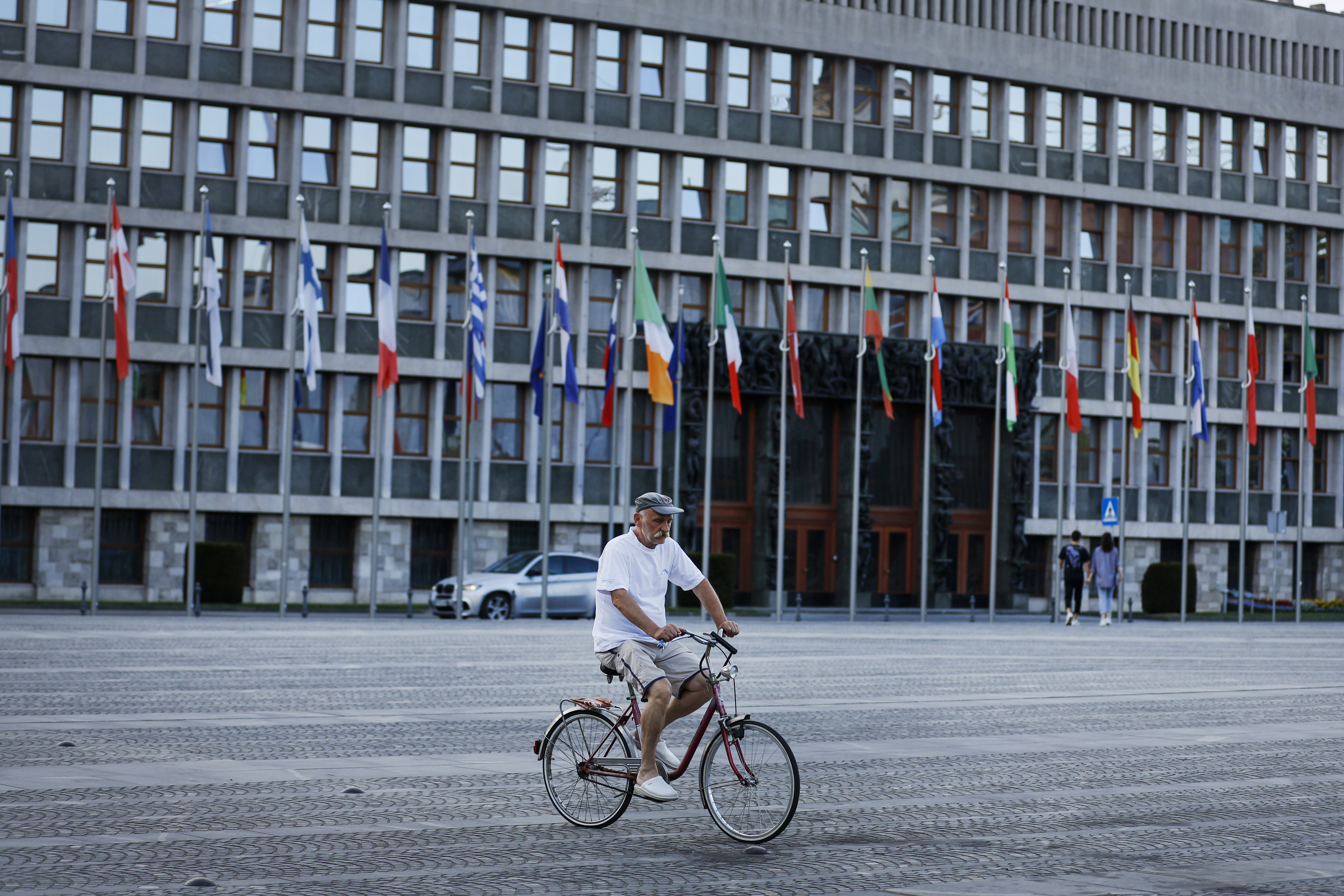 A cyclist rides past the European flags in front of the Slovenia Parliament building in Ljubljana, on June 29. The European Climate Law is a milestone in the global transition to climate neutrality. Photo: AP