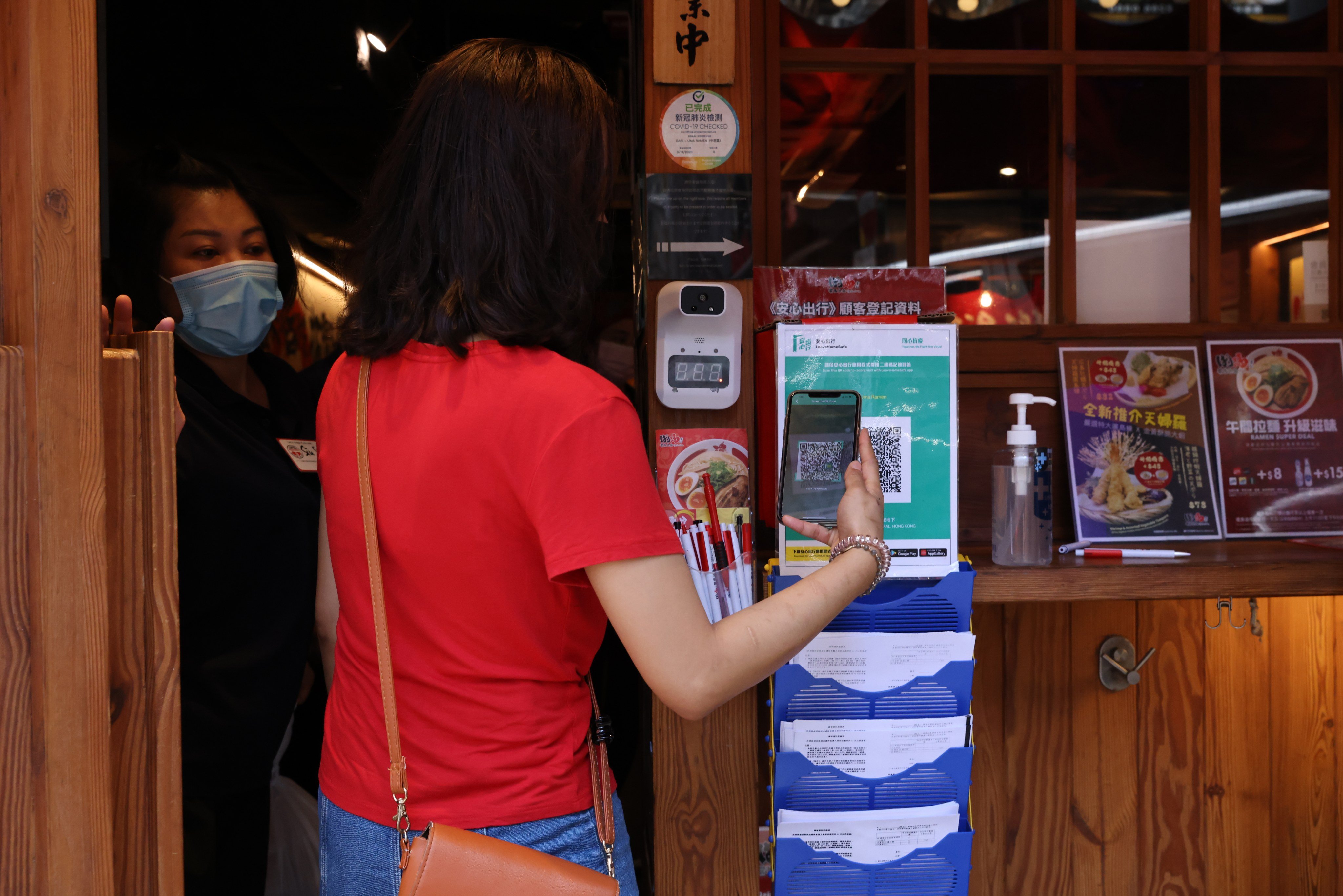 Customers are required to scan the QR code of the Leave Home Safe mobile app at a restaurant at Lan Kwai Fong in Central on June 3. Photo: May Tse