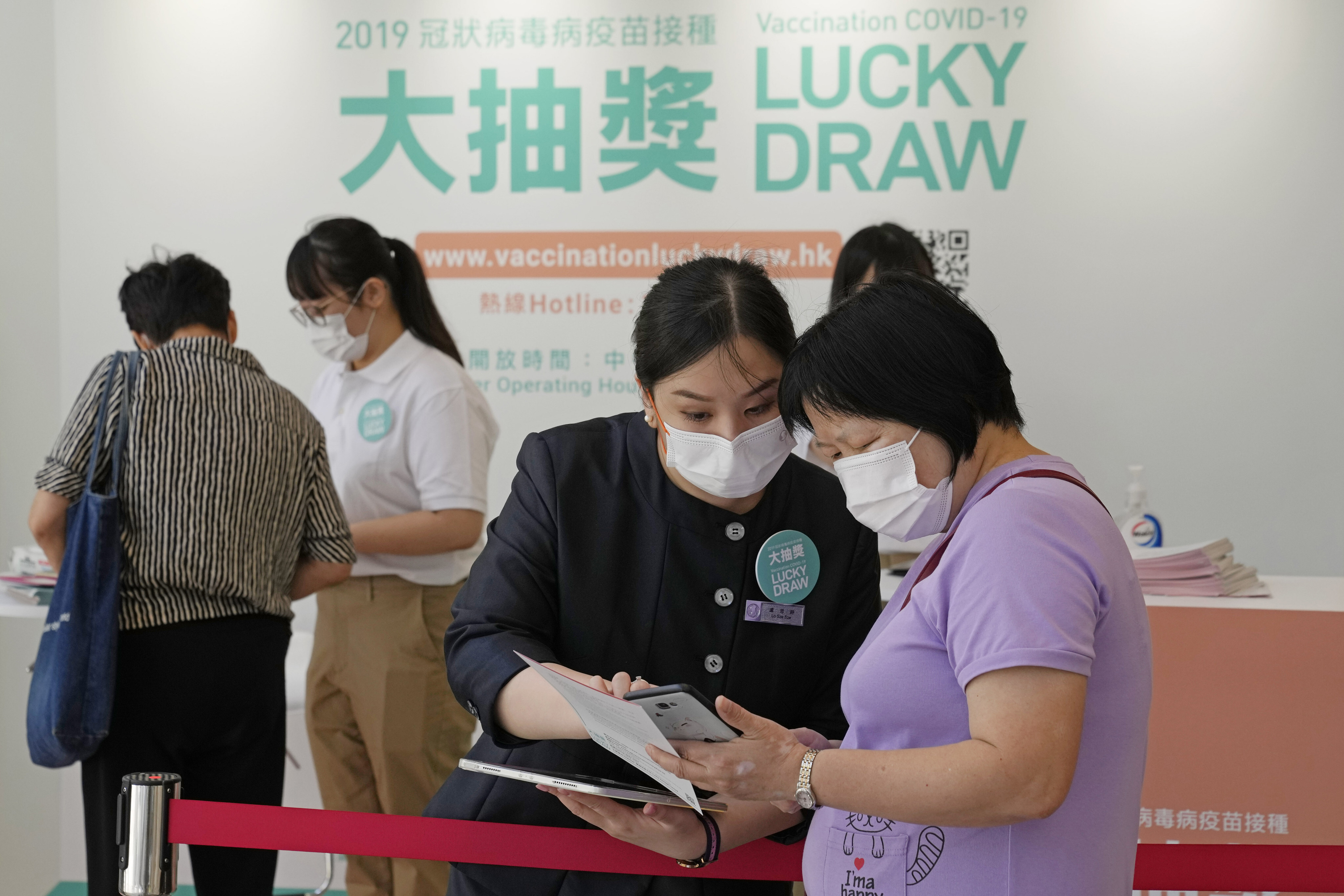 People register for the chance to win a HK$10.8 million in the Grand Central residential building complex in Kwun Tong, Hong Kong, one of many prizes being offered as a prize for being vaccinated. Photo: AP