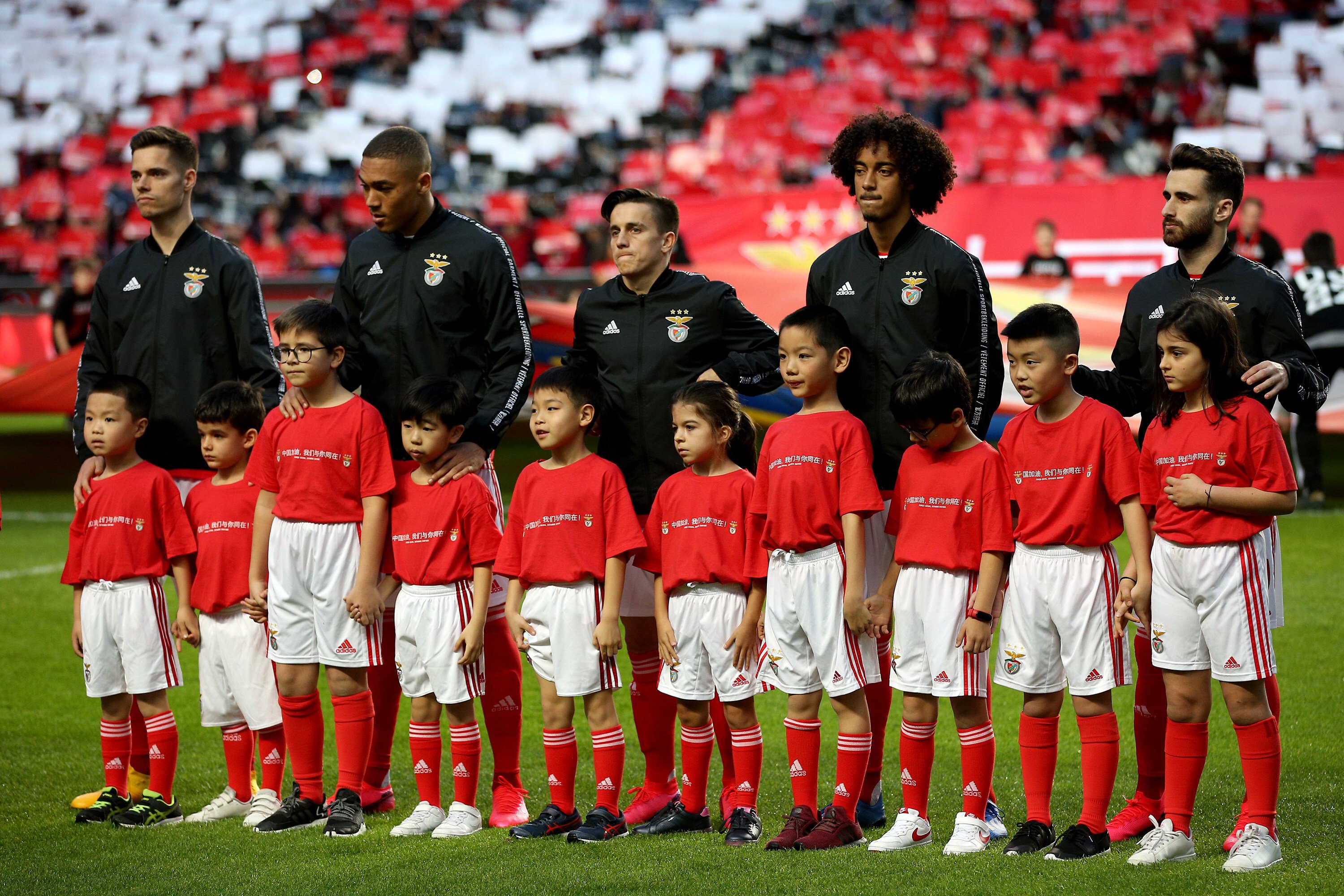 Portuguese professional football club players pose with Chinese children ahead of a game, during a brief ceremony to express solidarity with China’s fight against the Covid-19 pandemic, at the Luz stadium in Lisbon on February 15, 2020. Photo: Xinhua 