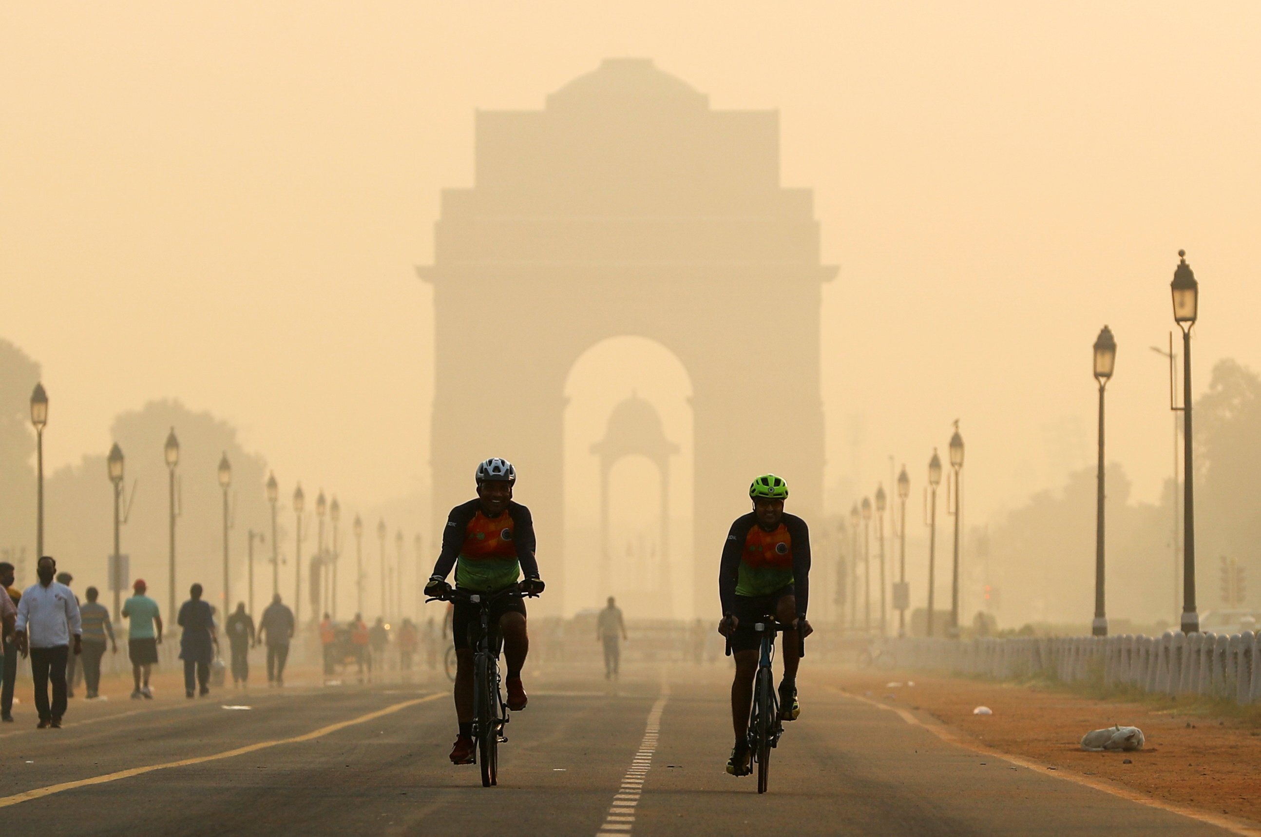 Men ride their bicycles in front of the India Gate shrouded in smog, in New Delhi, India, on October 24, 2020. A UN report projects New Delhi will overtake Tokyo as the world’s most populated mega-city in 2030. Photo: Reuters