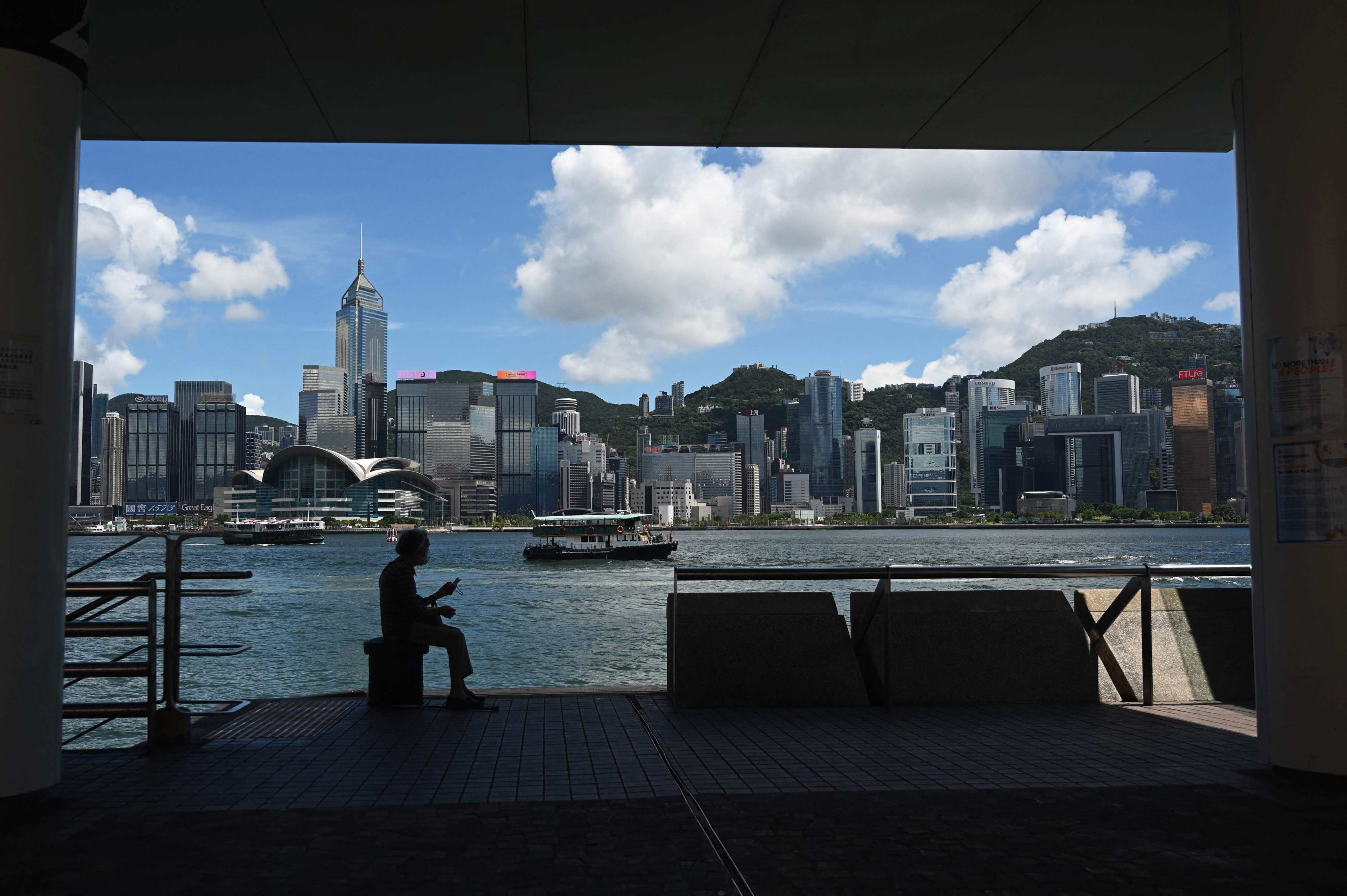 A woman sits by the Victoria Harbour in Hong Kong on July 12. Hong Kong has been successful in controlling specific air pollutants, and new plans announced in an updated Clean Air Plan for Hong Kong 2035 will result in further improvement. Photo: AFP