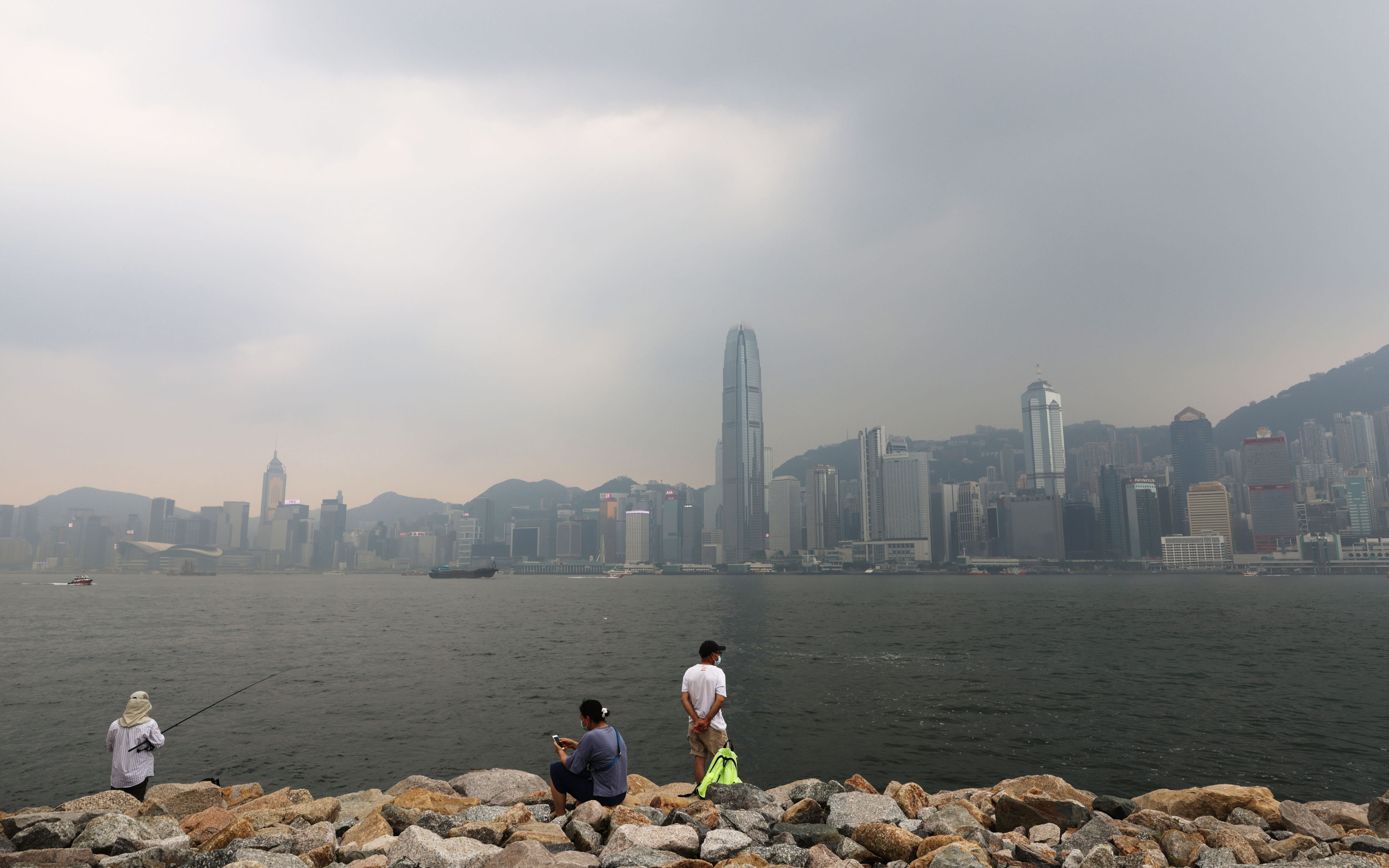 People look towards Hong Kong Island from the waterfront at the West Kowloon Cultural District as air pollution hangs over the city. Photo: May Tse