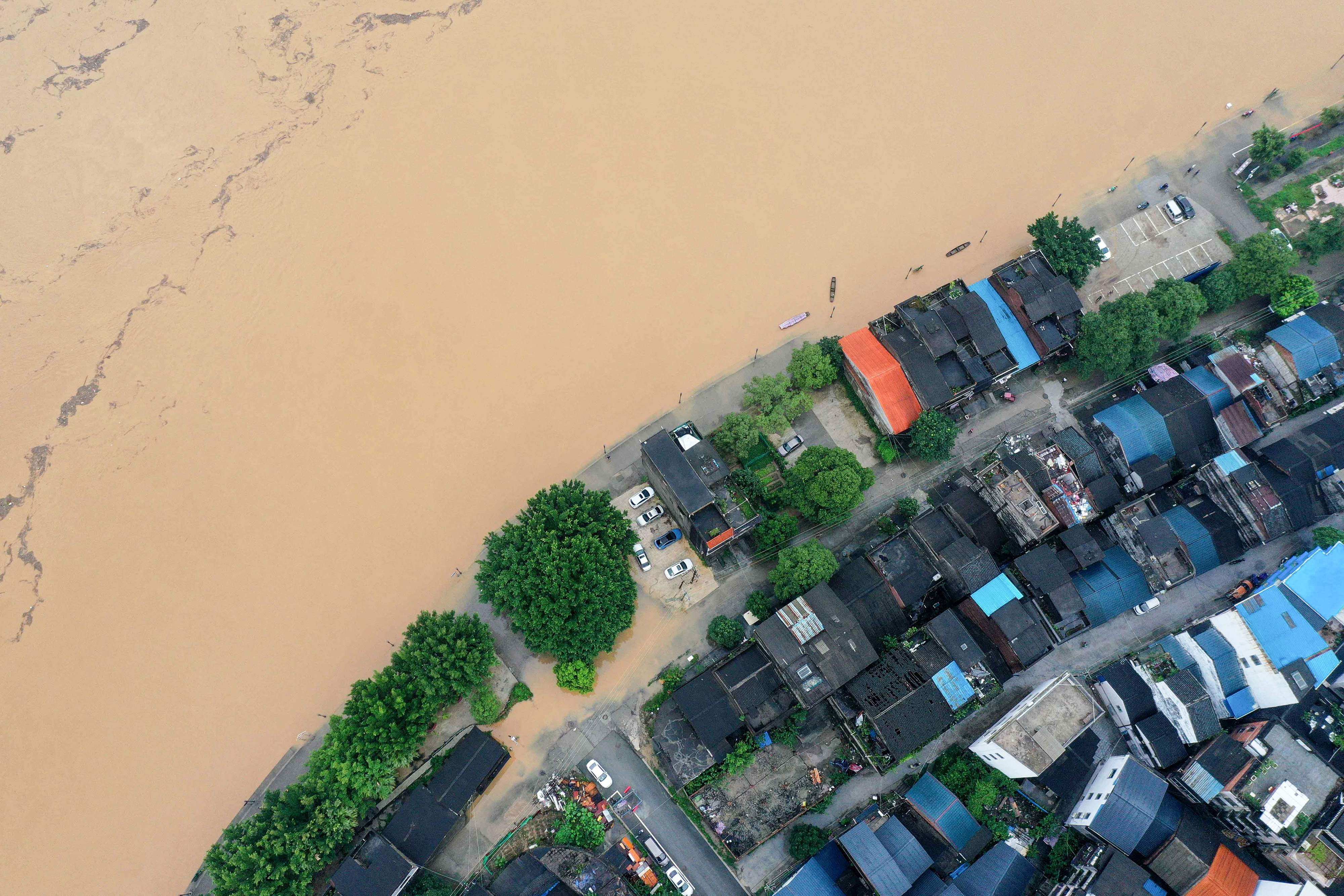 A flooded street along the swollen Rongjiang river after heavy rains in Rongan, in China’s southern Guangxi region, on July 2. Waves of change are to be expected, but they become unmanageable when they collide to create massive shocks. Climate change driven by economic growth is one example. Photo: AFP