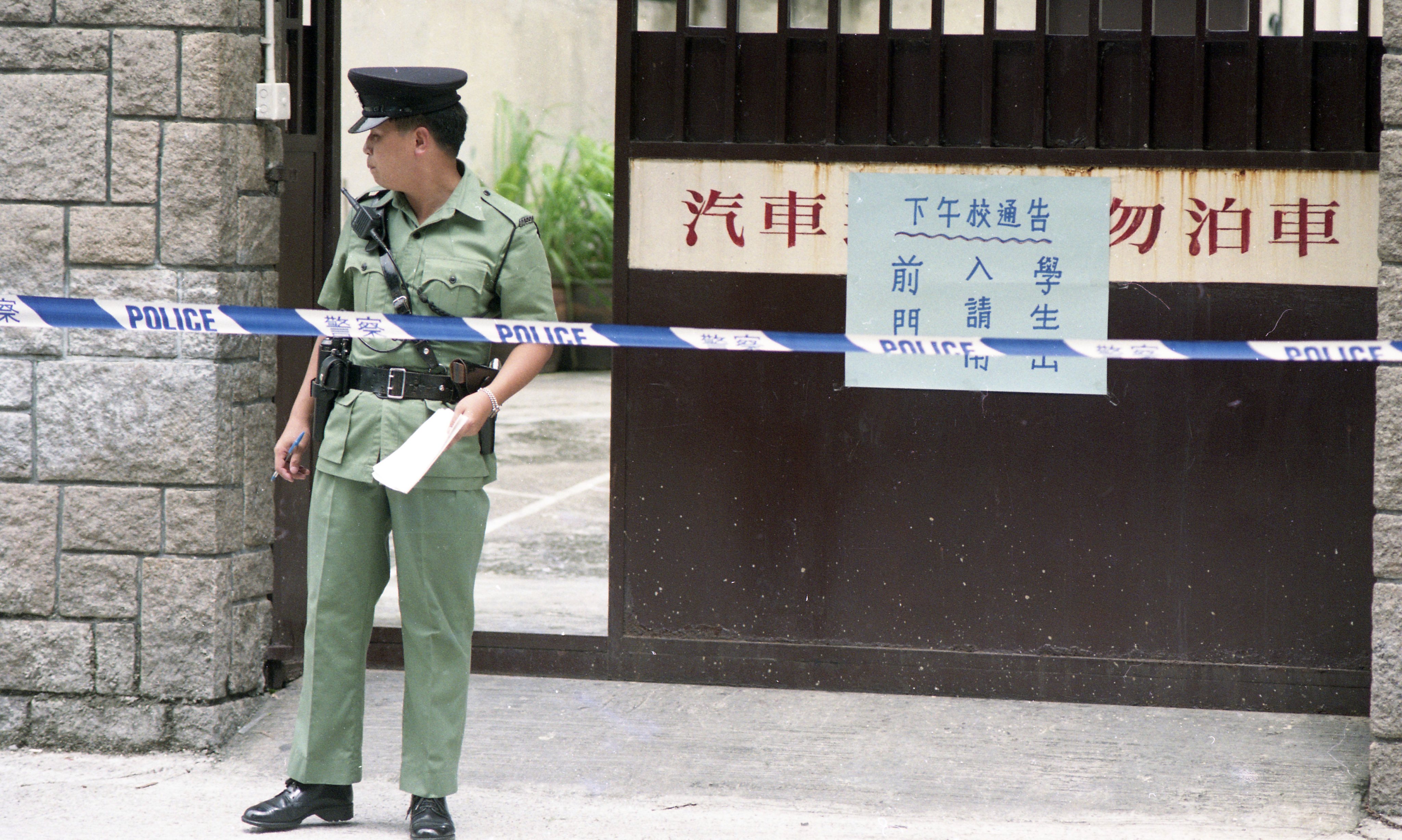 Police officers cordon off a crime scene at Good Shepherd Primary School, in To Kwa Wan in 1993. The headmaster of the school was arrested for the death of a school accounts clerk. Photo: Martin Chan