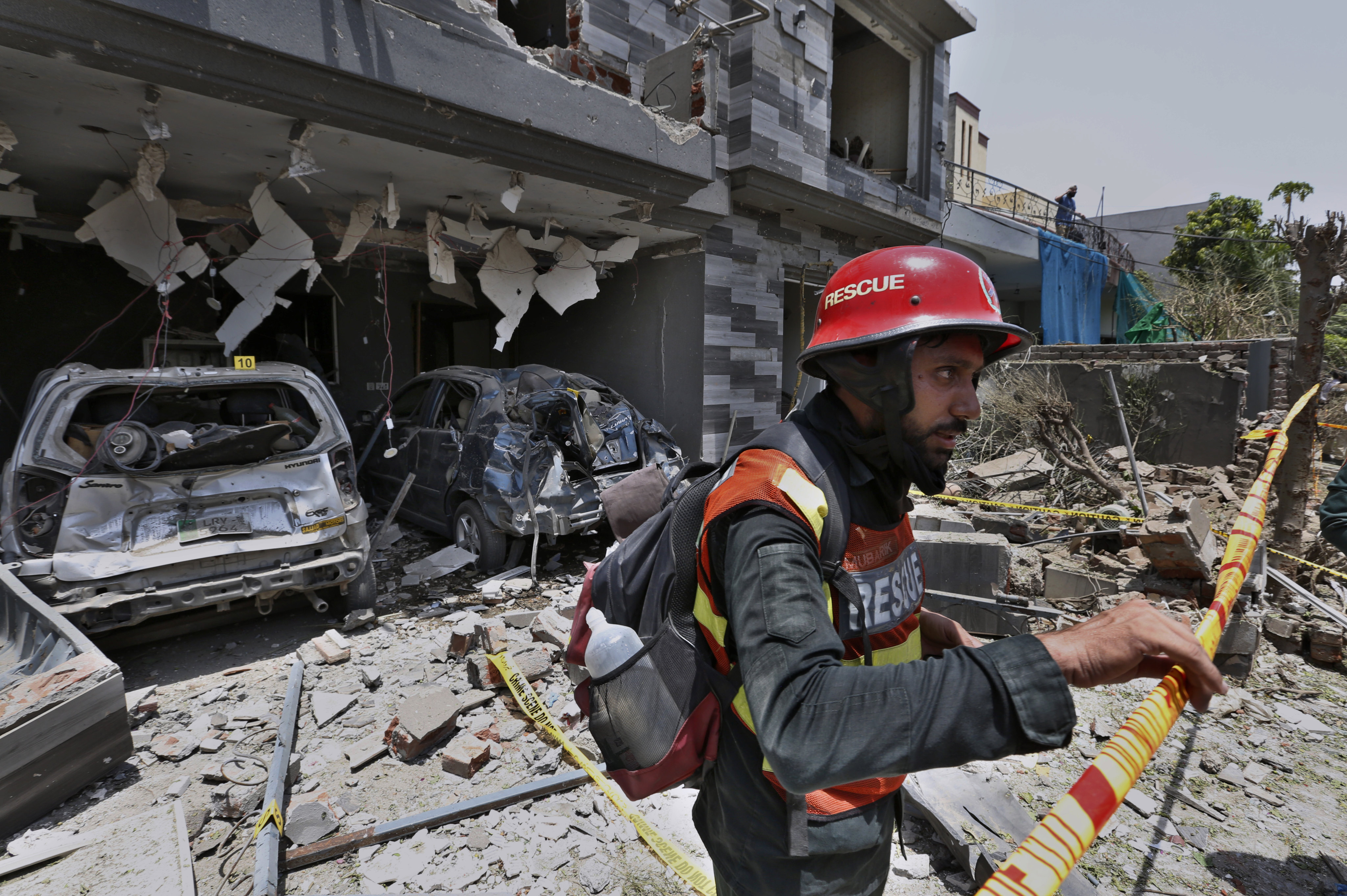 A rescue worker examines the site of an explosion in Lahore, Pakistan, on June 23. Pakistan’s national adviser has accused India of orchestrating the deadly car bombing. Photo: AP