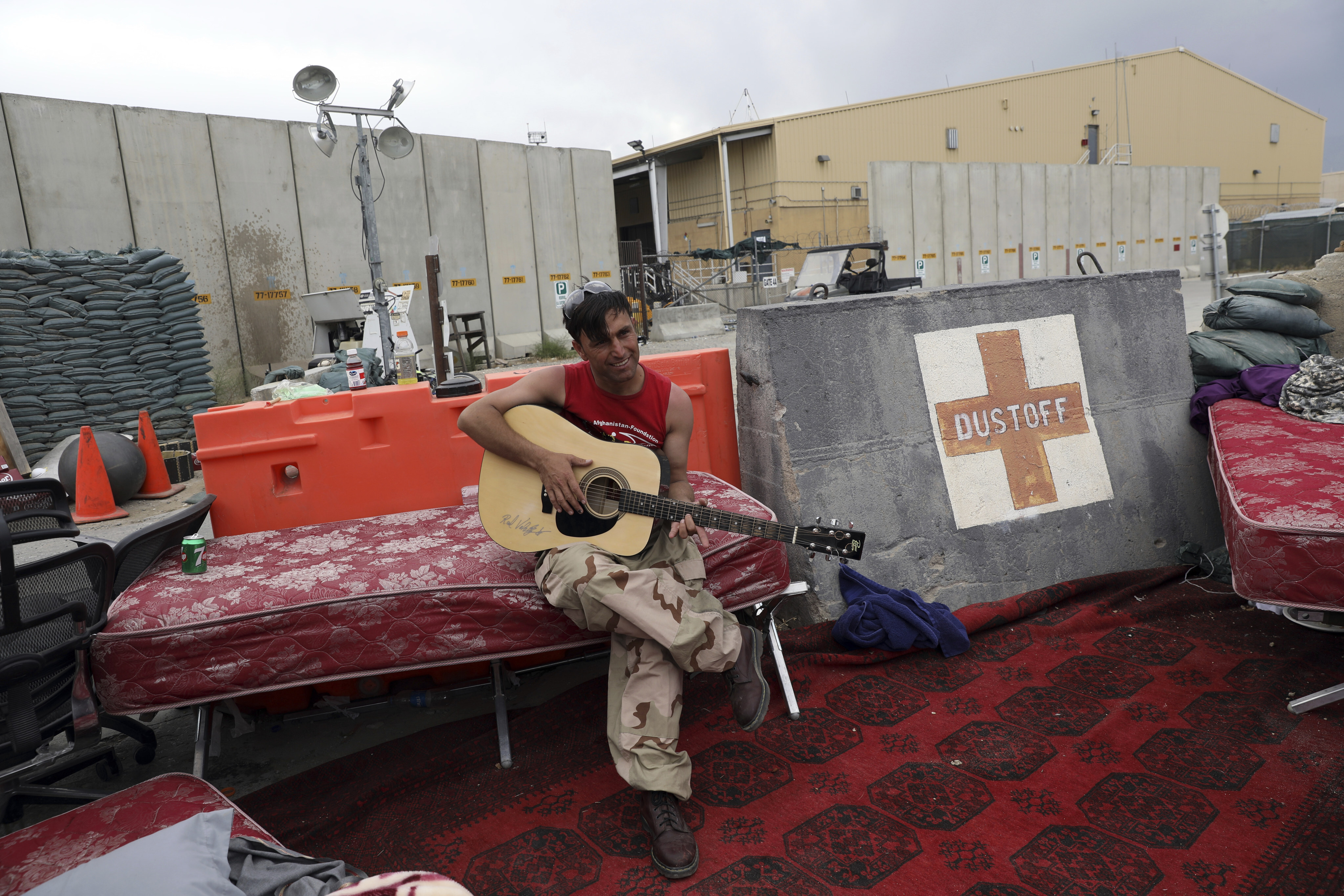 An Afghan soldier plays a guitar that was left behind after the American military departed Bagram air base in Afghanistan on July 5. Photo: AP