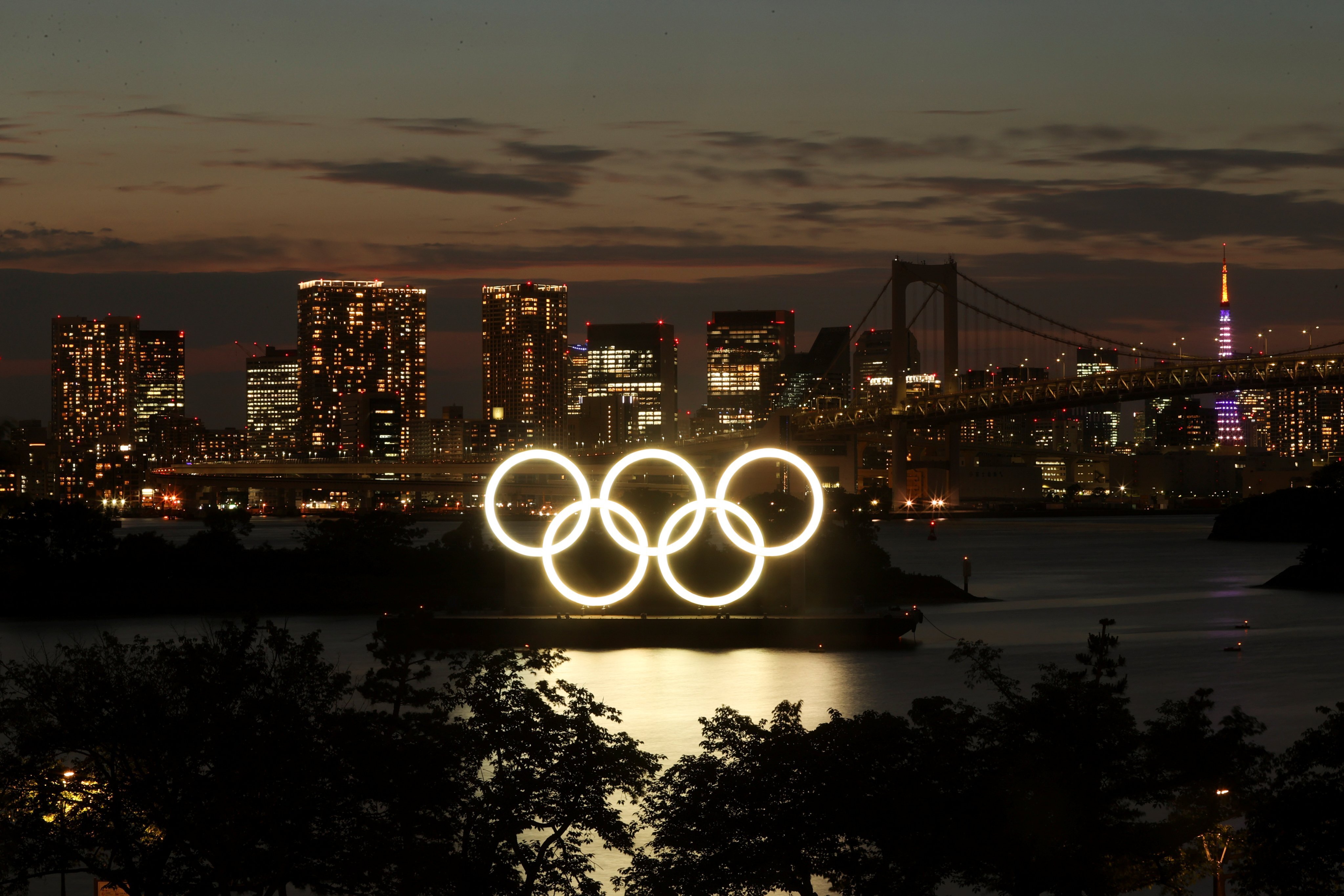 A general view of the Olympic Rings installed on a floating platform with the Rainbow Bridge in the background in preparation for the Tokyo 2020 Olympic Games in Tokyo, Japan, on June 21, 2021. Photo: Reuters
