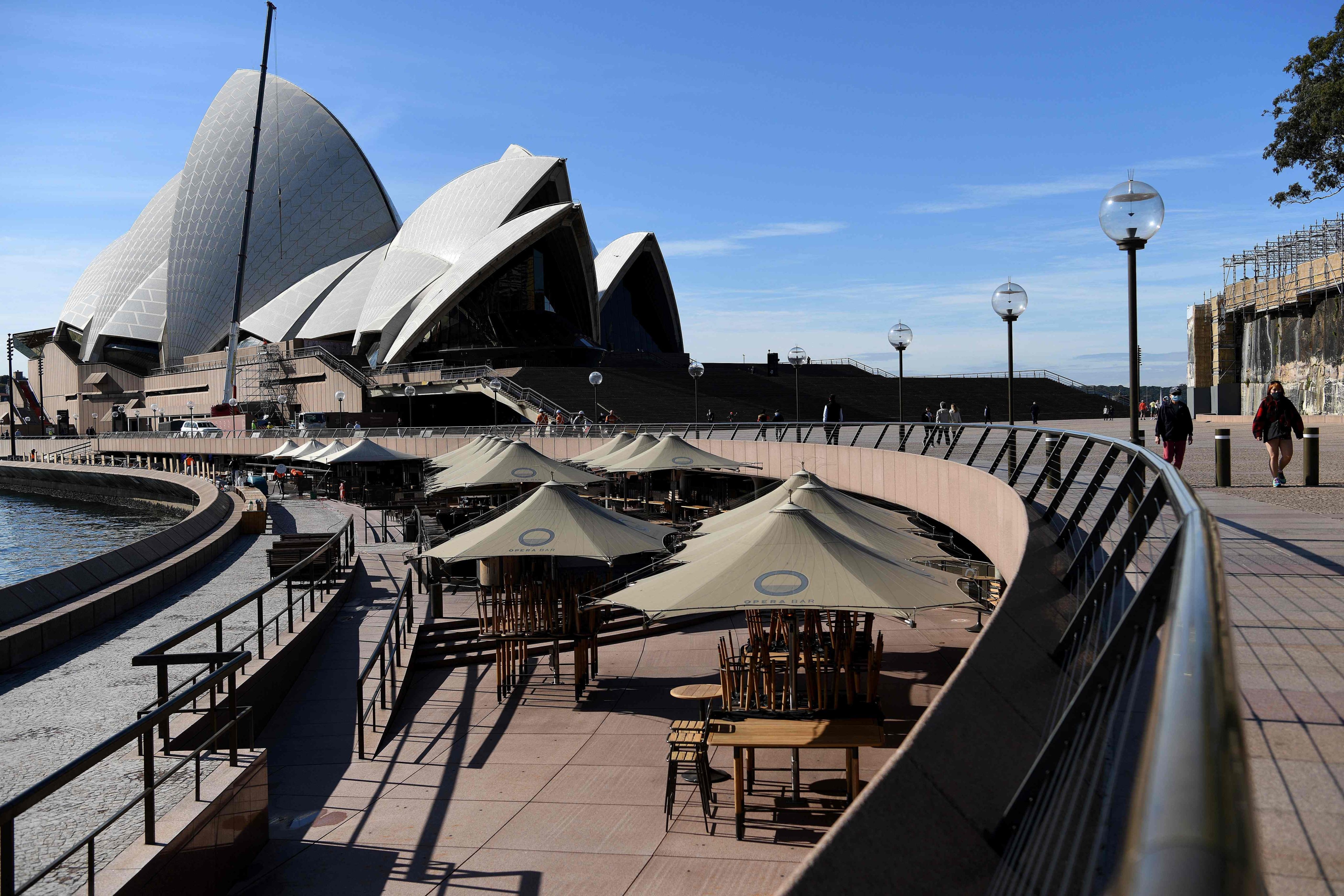 Chairs are piled up on tables at a closed restaurant near the Sydney Opera House on July 6 during a lockdown to contain an outbreak of the highly contagious Covid-19 Delta variant in Australia. Photo: AFP