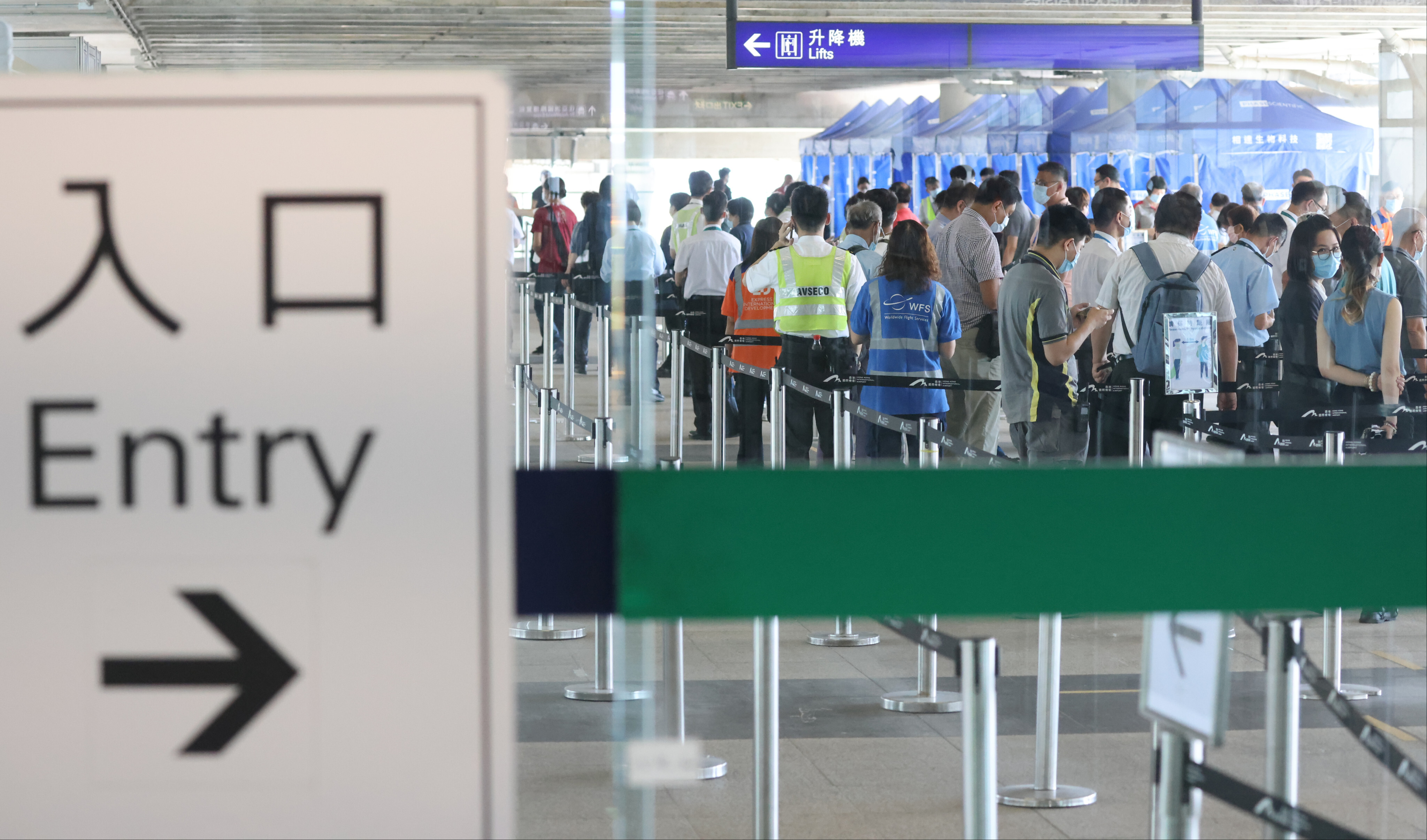 Airport staff subject to compulsory testing queue up for Covid testing at a mobile specimen collection station  in Terminal 1 of the Hong Kong International Airport on July 13. Photo: Nora Tam