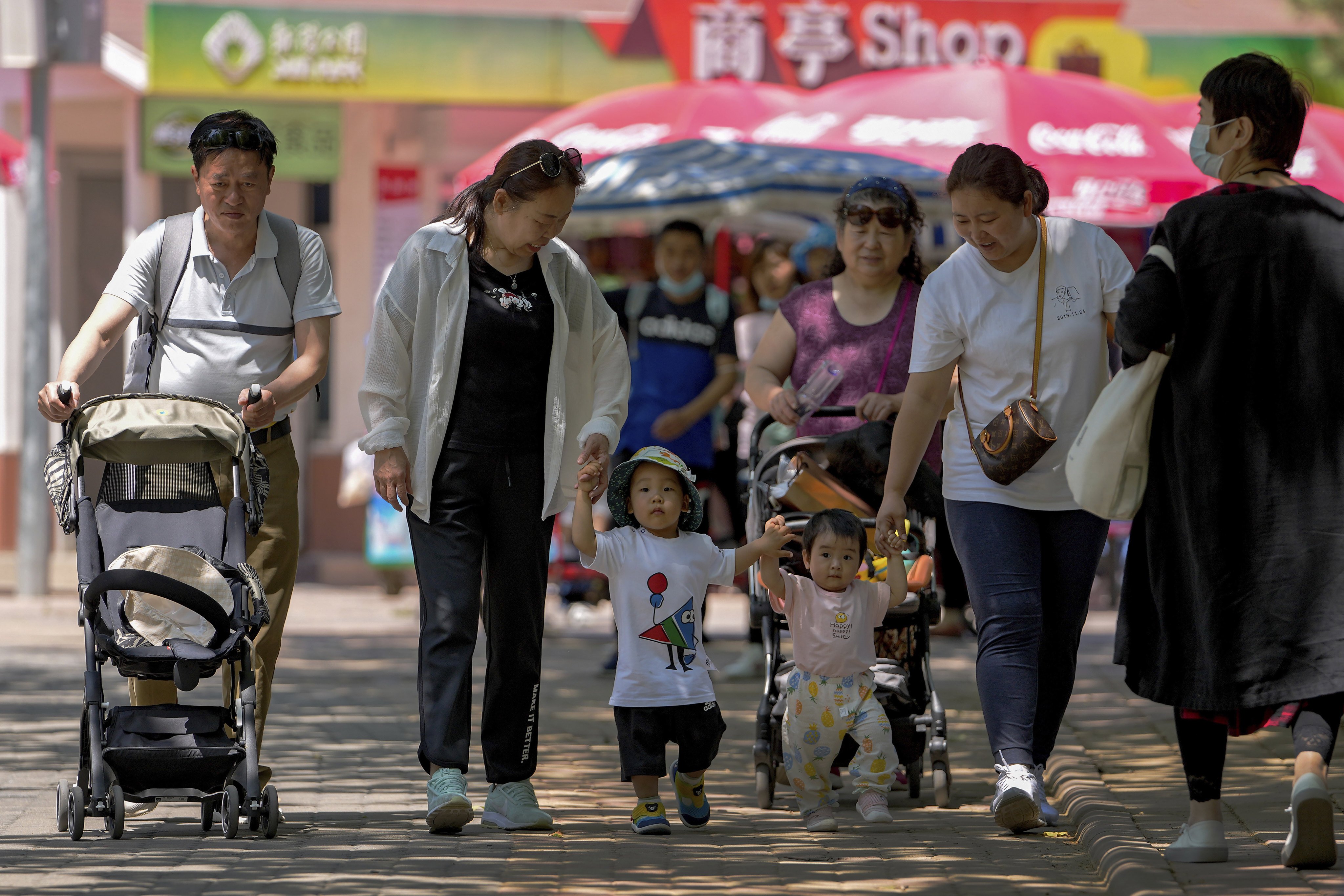 Families walk through a public park on International Children’s Day in Beijing, on June 1. Photo: AP 