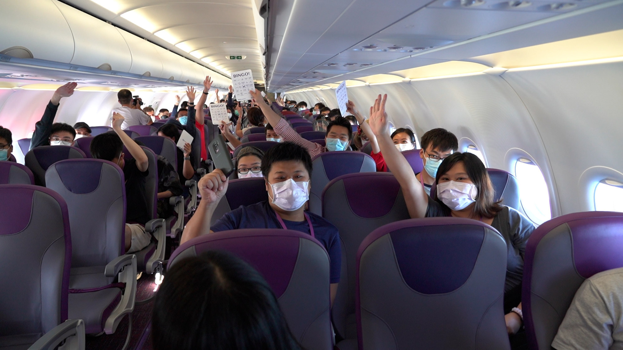 Passengers play a game with crew members on board an HK Express “flight to nowhere”.