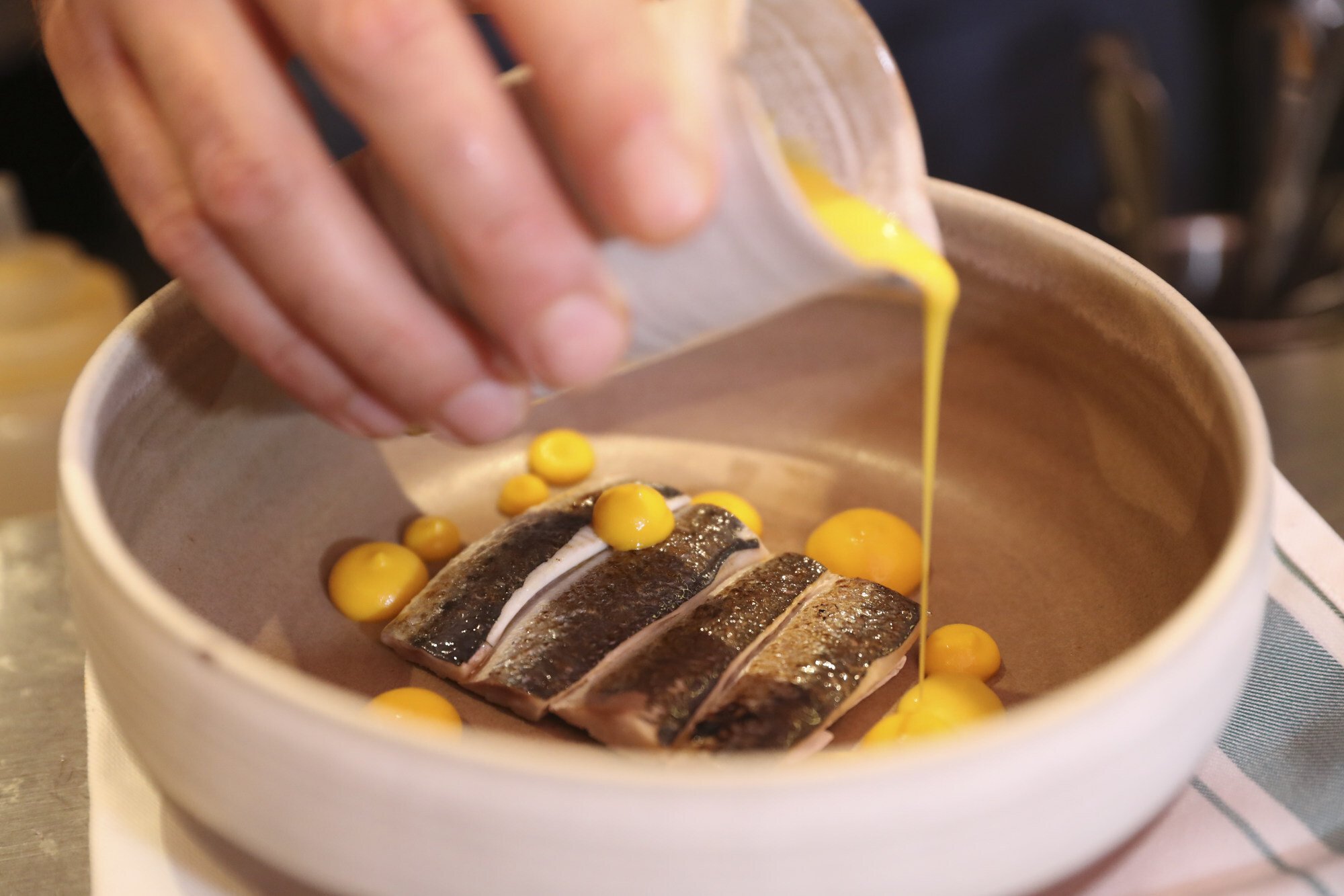 Chef Oviedo adds the finishing touches to a dish of Atlantic sardines in carrot escabeche at 22 Ships in Wan Chai. Photo: Edmond So