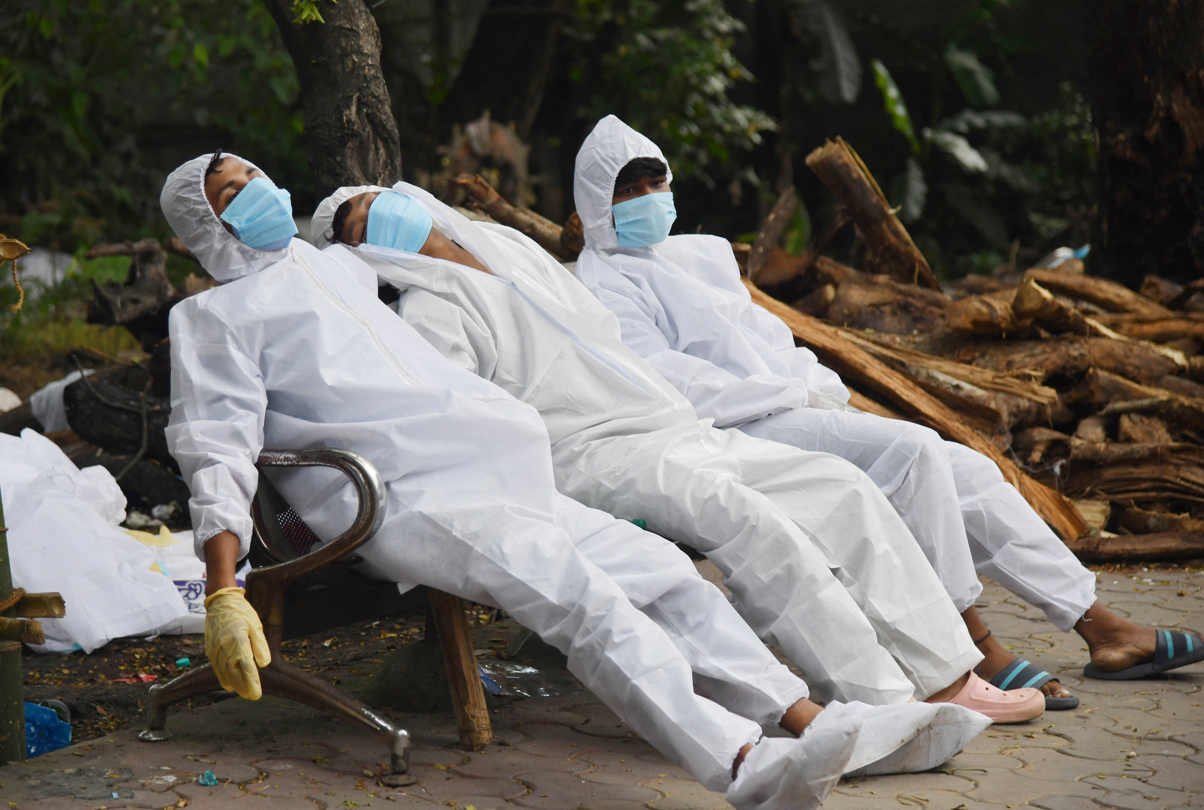 Ambulance staff rest on a bench after their Covid-19 coronavirus duty at a crematorium ground in Guwahati on June 25, 2021. (Photo by Biju BORO / AFP)&#xA;&#xA;CREDIT: AFP