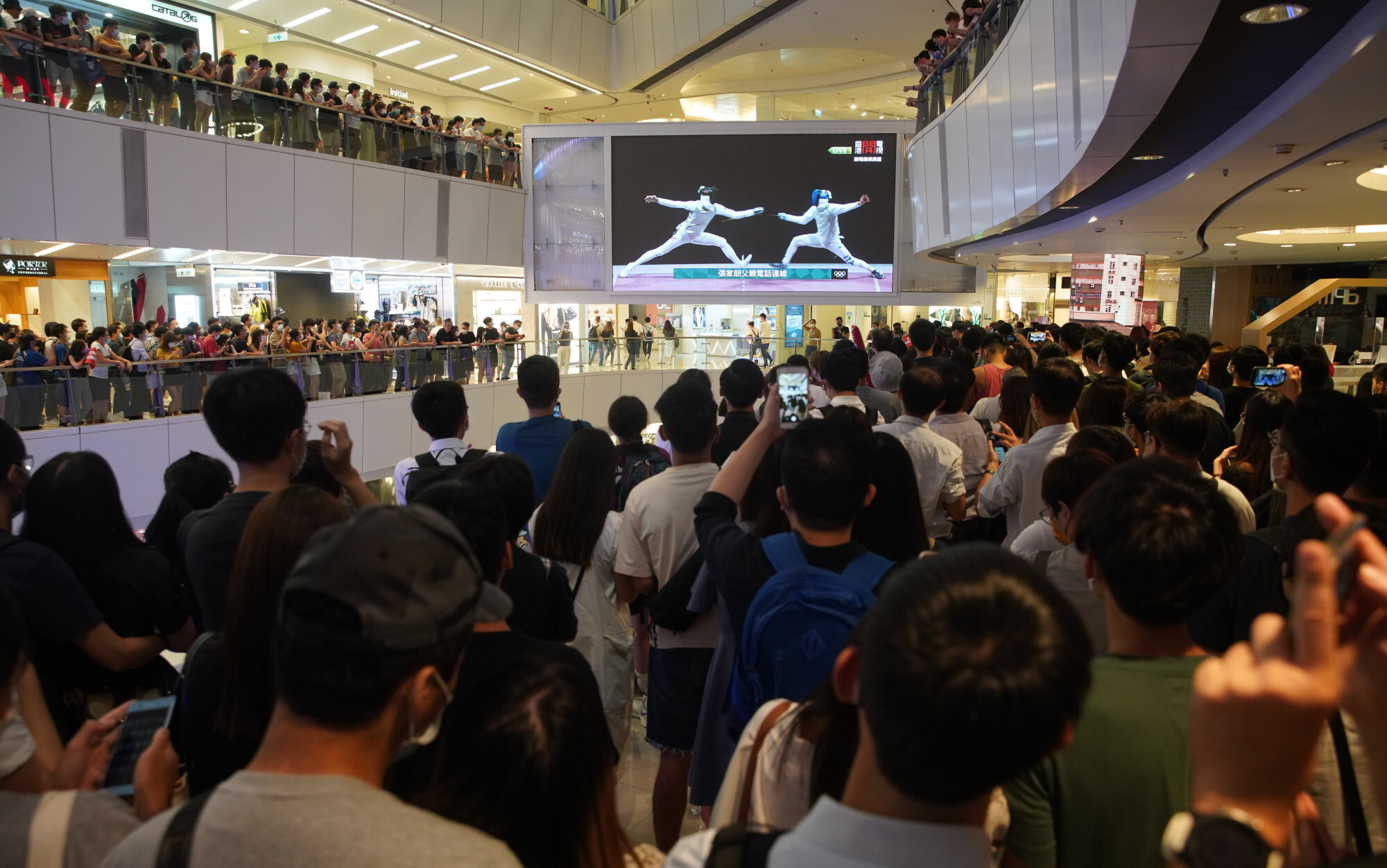 Hongkongers watch the live coverage of fencer Cheung Ka-long beating Daniele Garozzo of Italy on a huge television screen in APM shopping centre in Kwun Tong. Photo: Winson Wong