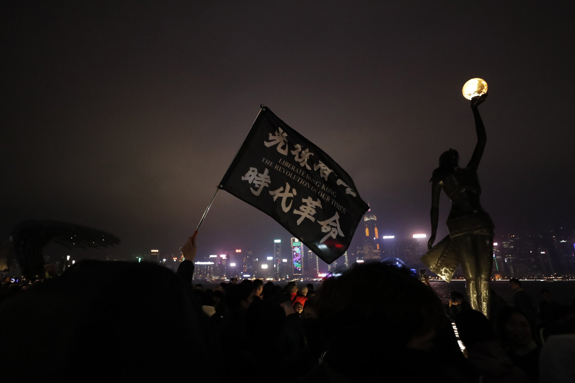A protester holds a flag reading “Liberate Hong Kong, revolution of our times” during a demonstration in Hong Kong on December 31, 2019. This slogan was widely used, along with “Five demands, not one less”, to stir up passion for the protest movement. Photo: AP
