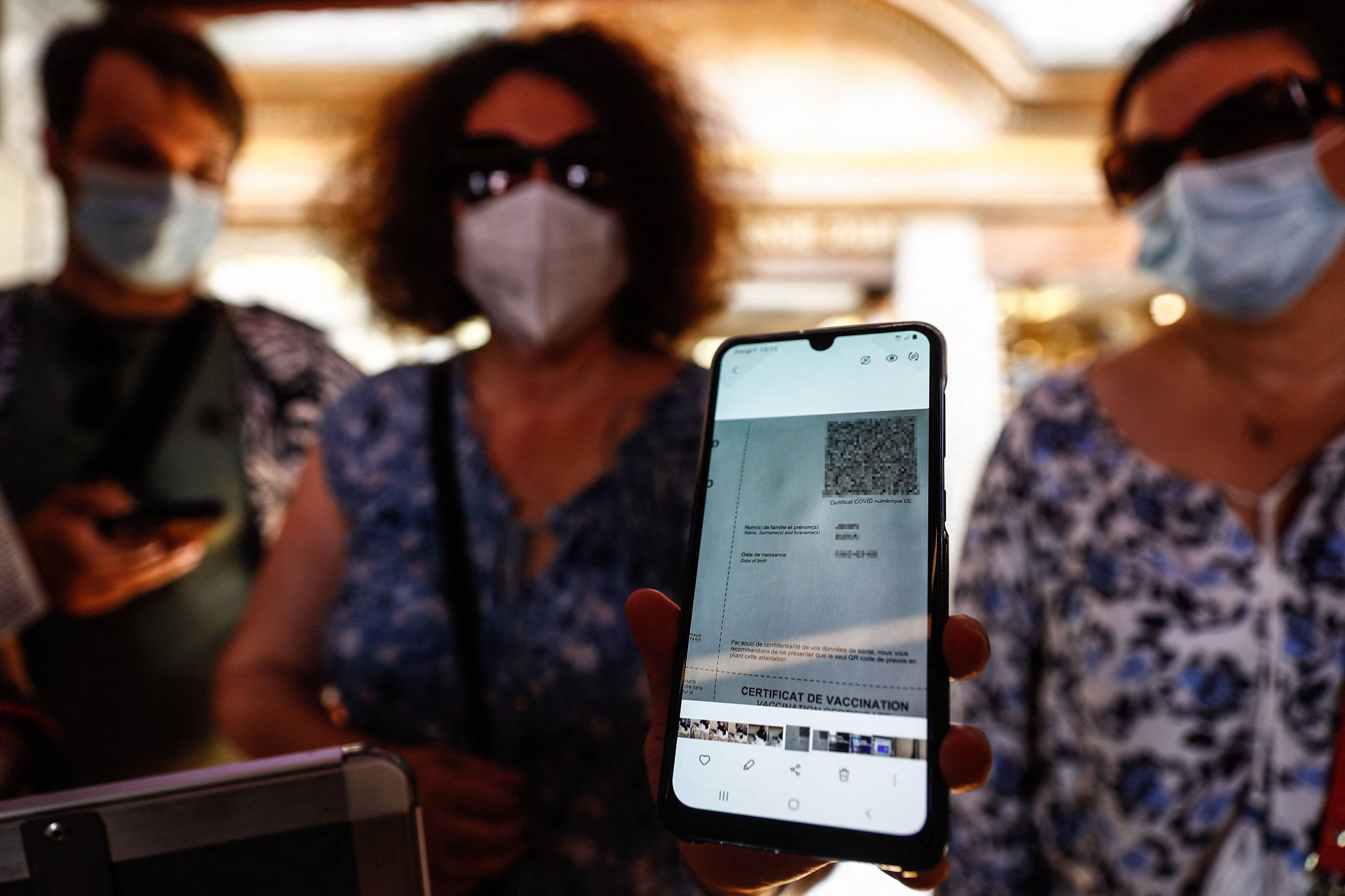 A woman shows her health pass as she arrives at a restaurant in Mont-Saint-Michel, in Normandy, northwestern France, on July 22. French cinemas, museums and sports venues have begun asking visitors to furnish proof of Covid-19 vaccination or a negative test as the country rolled out a vaccine passport system. Photo: AFP 