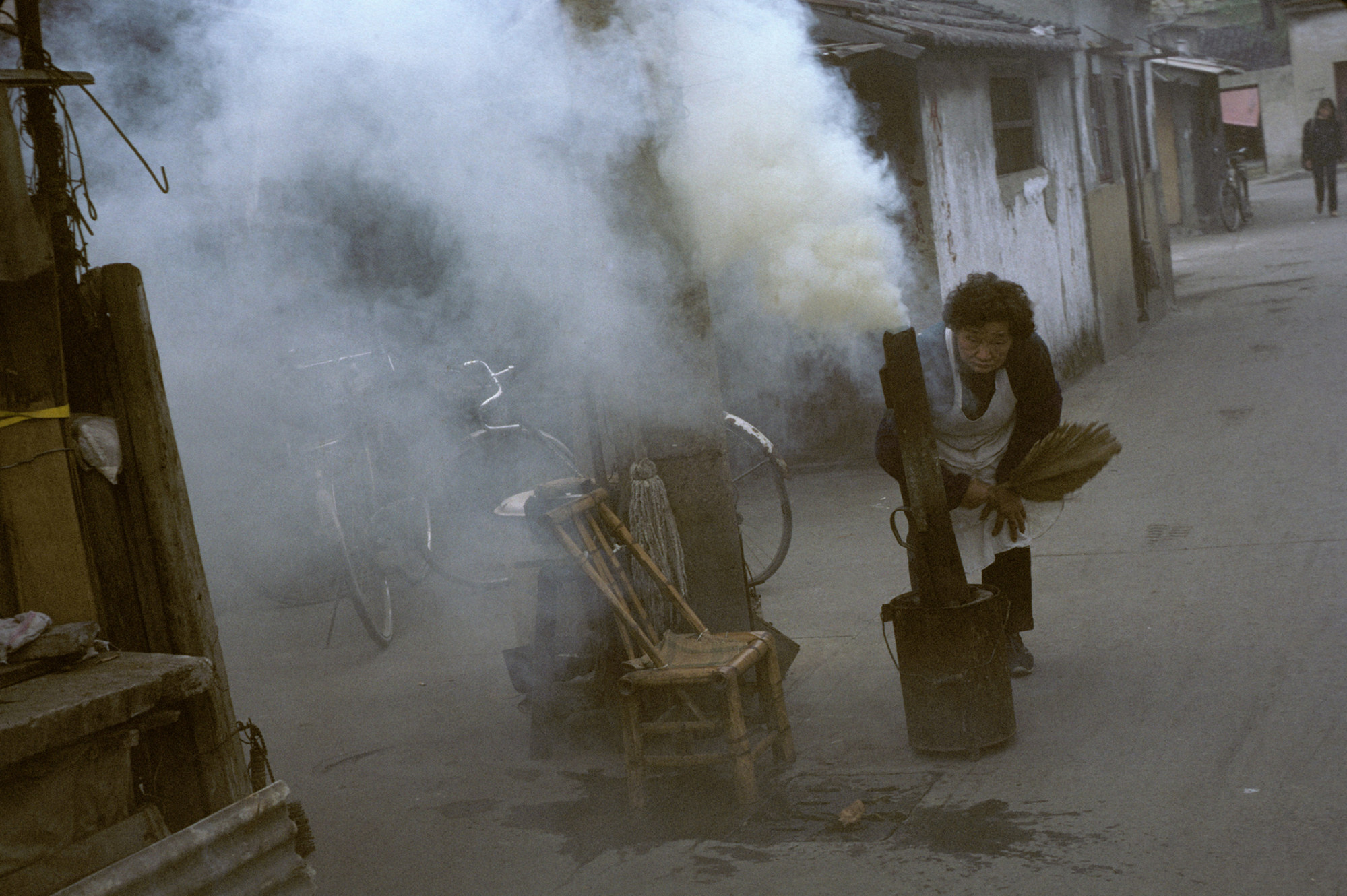 An woman makes smoke to keep mosquitoes away in an old district of Shanghai in August 1991. Photo: Getty Images